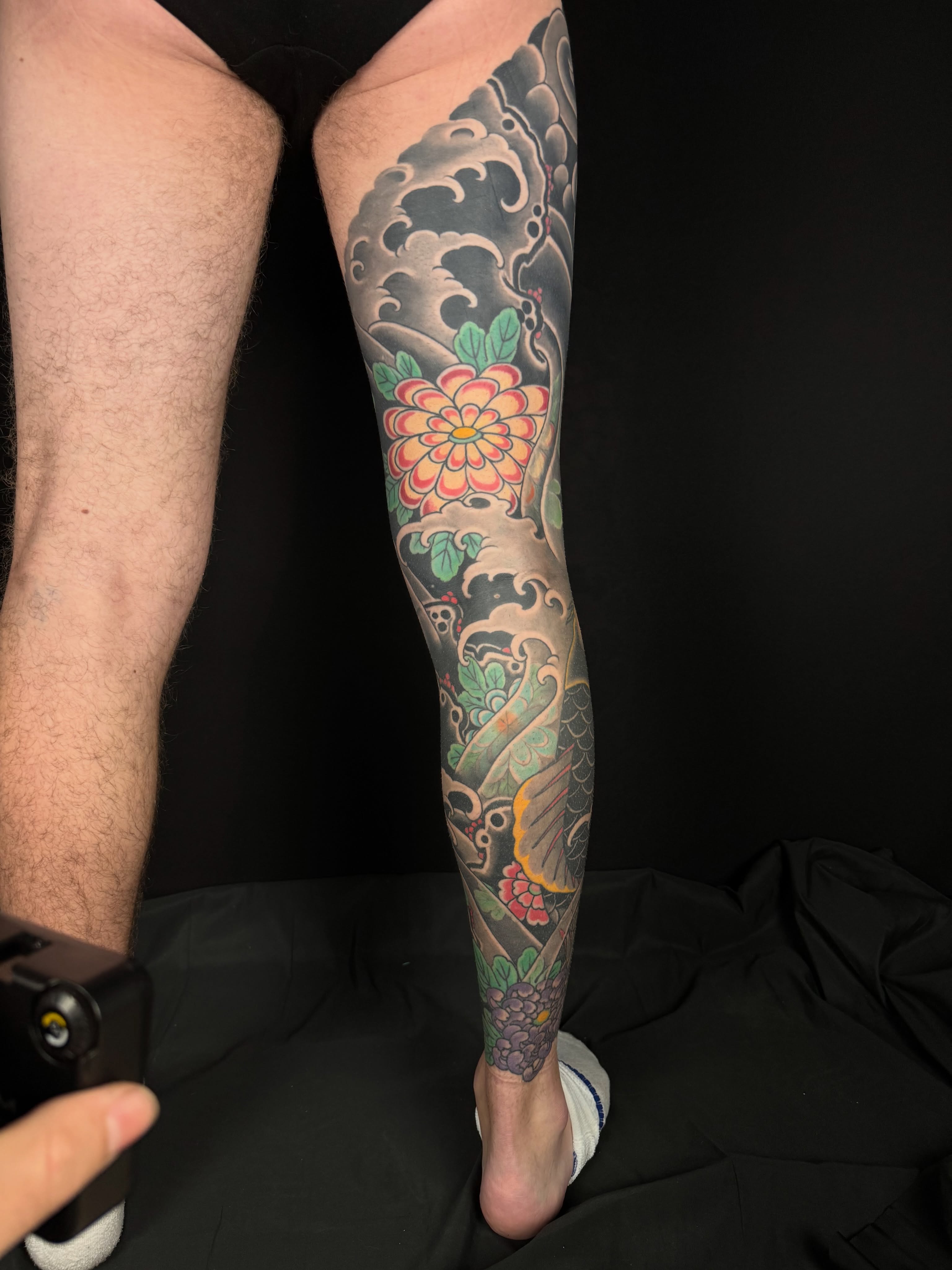 Wave and flower japanese irezumi tattoo on the calf by Leif Hansen