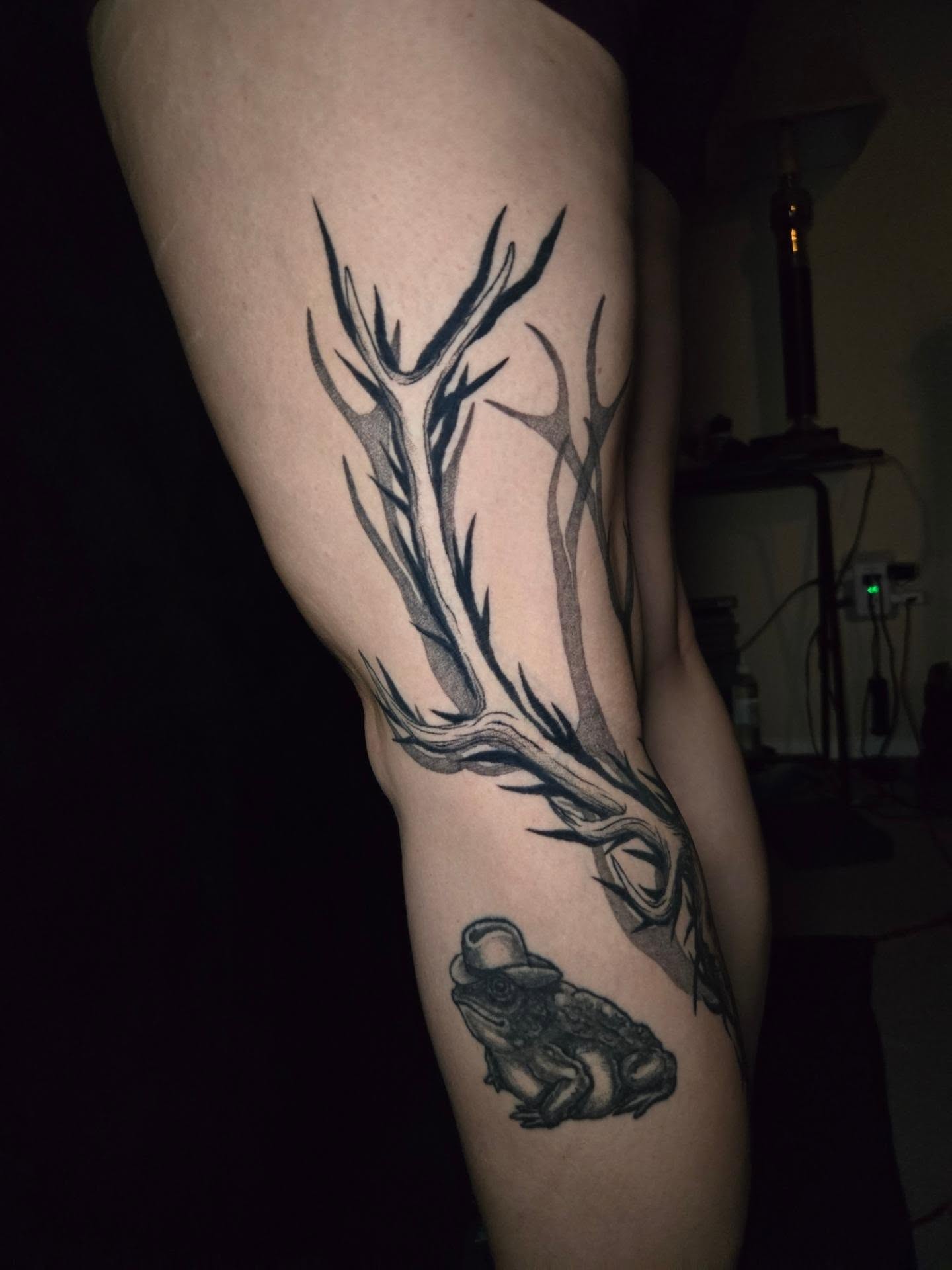 Antlers and frog black and grey tattoo on the forearm by Perry