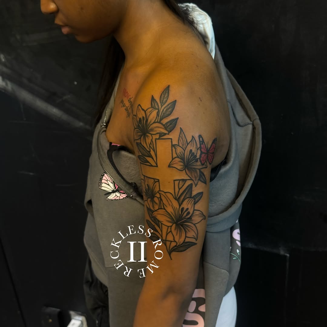 Cross and lilies American traditional tattoo on the shoulder by Rome