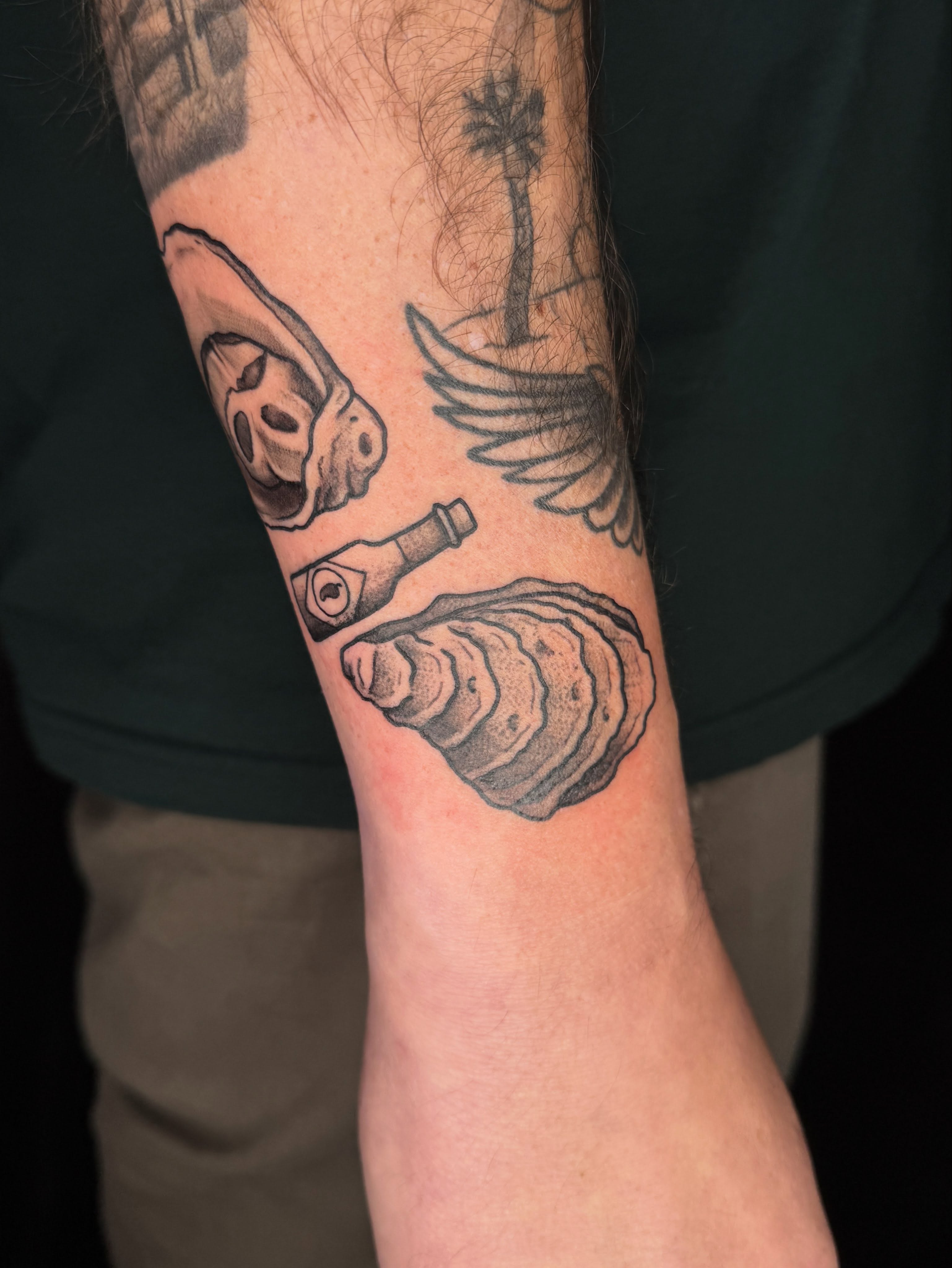 Oyster shell and bottle opener black and grey tattoo on the forearm by Cody Glenn