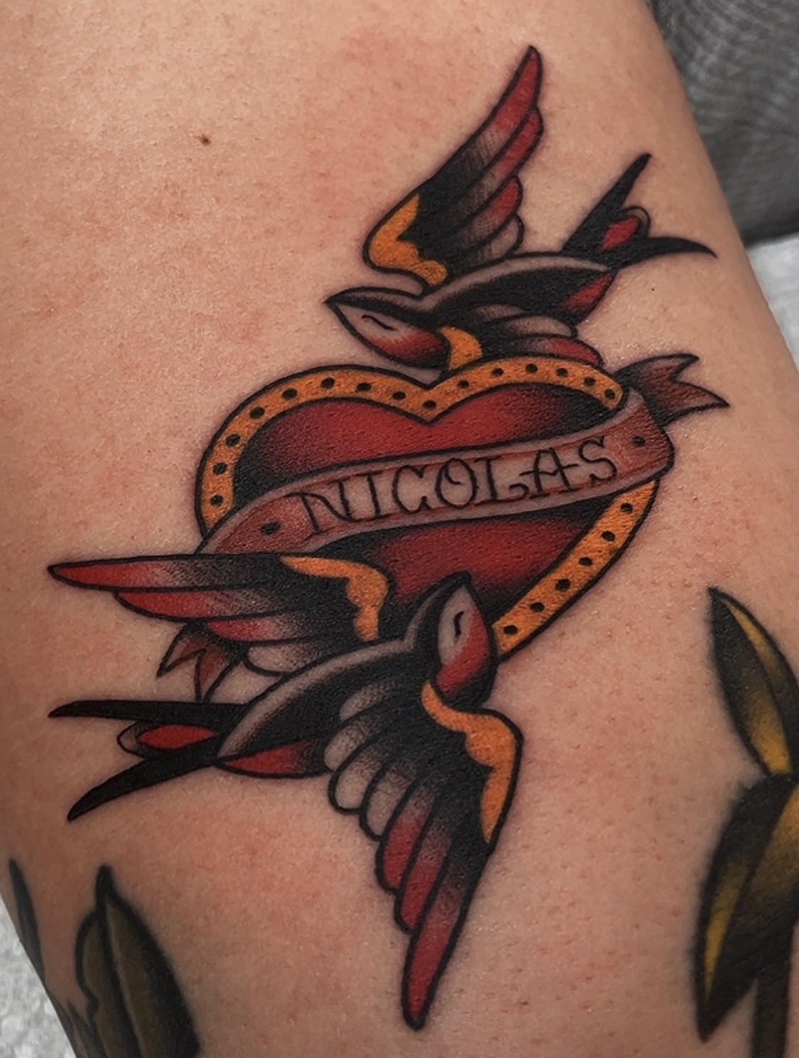 Heart with birds American traditional tattoo on the upper arm by Las Vegas Tattoo Artist
