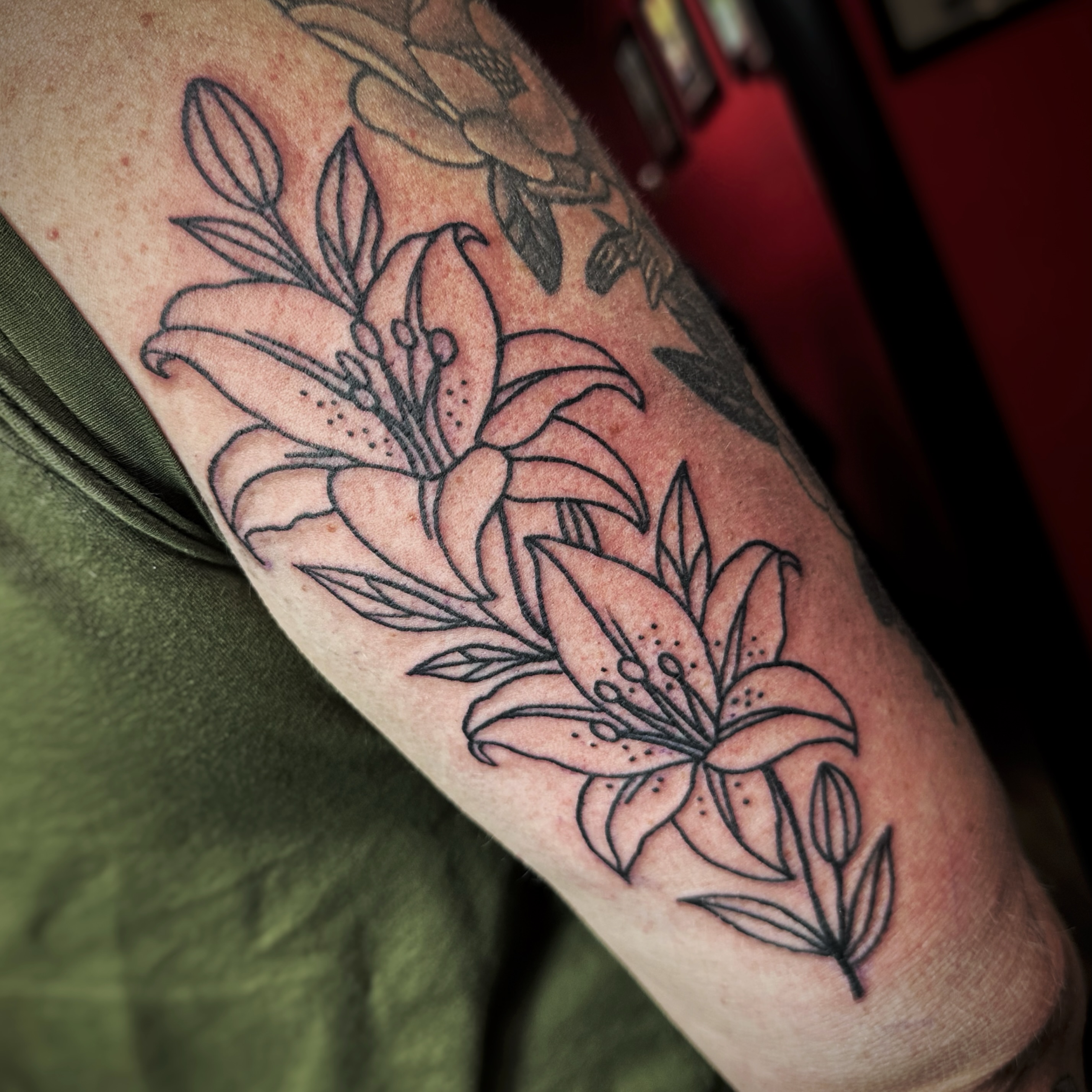 Lily flowers black and grey tattoo on the forearm by Anthony Guido