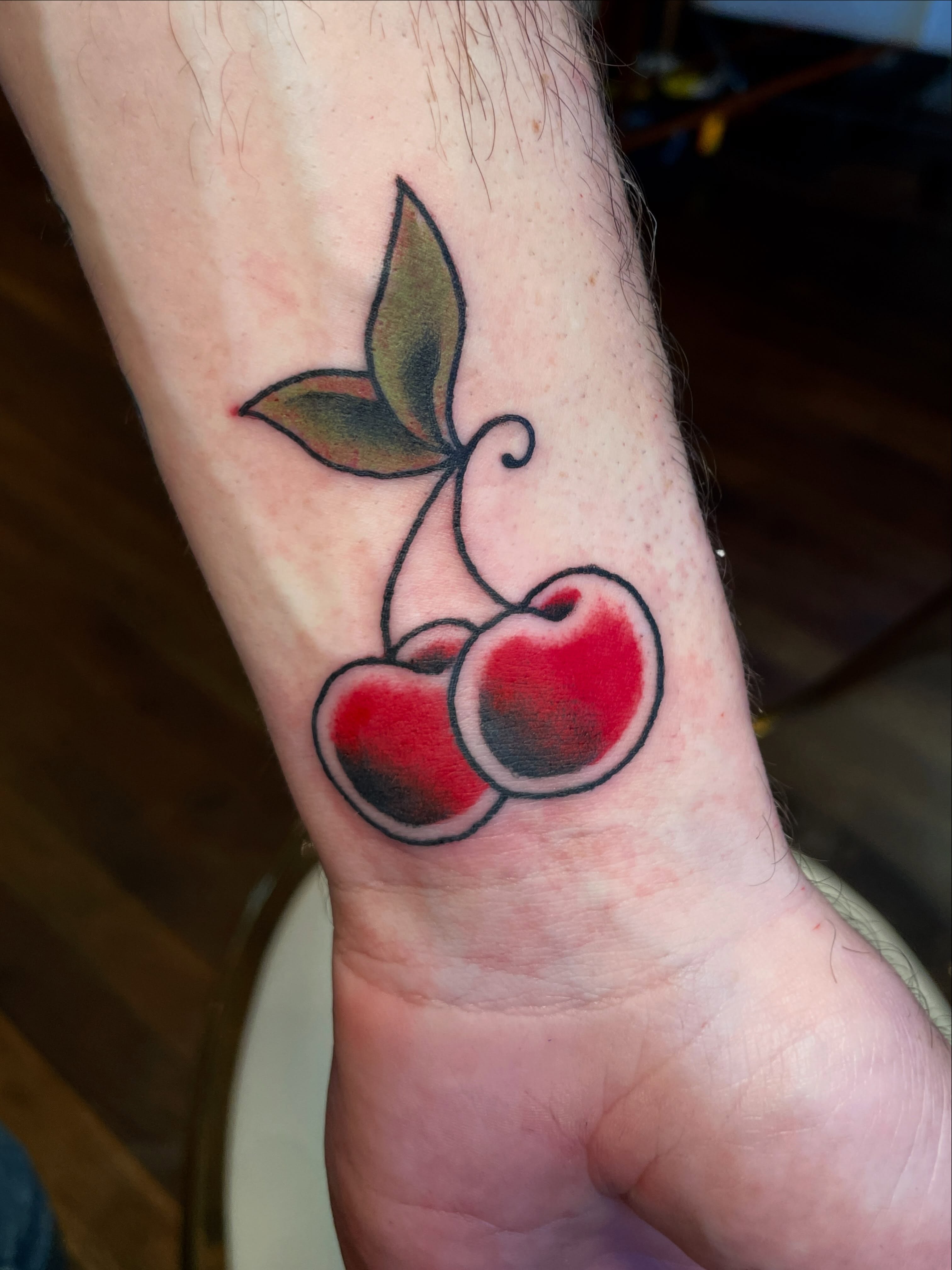 Cherries American traditional tattoo on the forearm by Nick Wallin