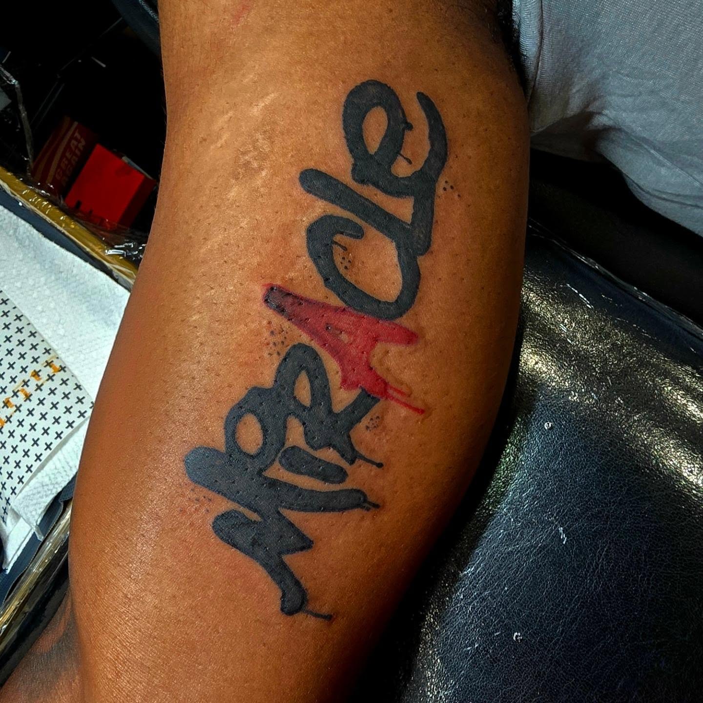 Miracle lettering script tattoo on the forearm by Captain Michael Devious
