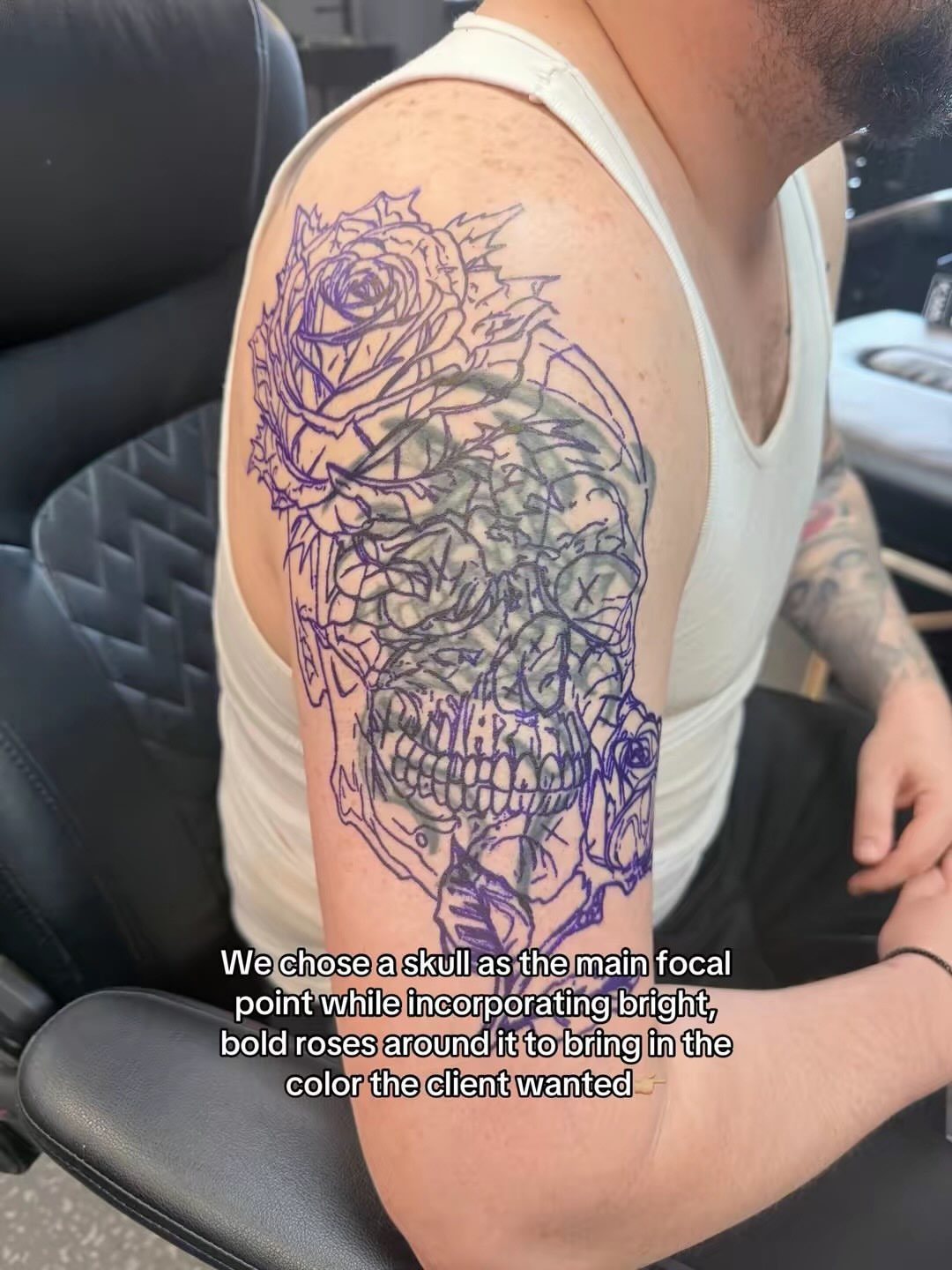 Skull with roses black and grey tattoo on the upper arm by Johnny Scillieri
