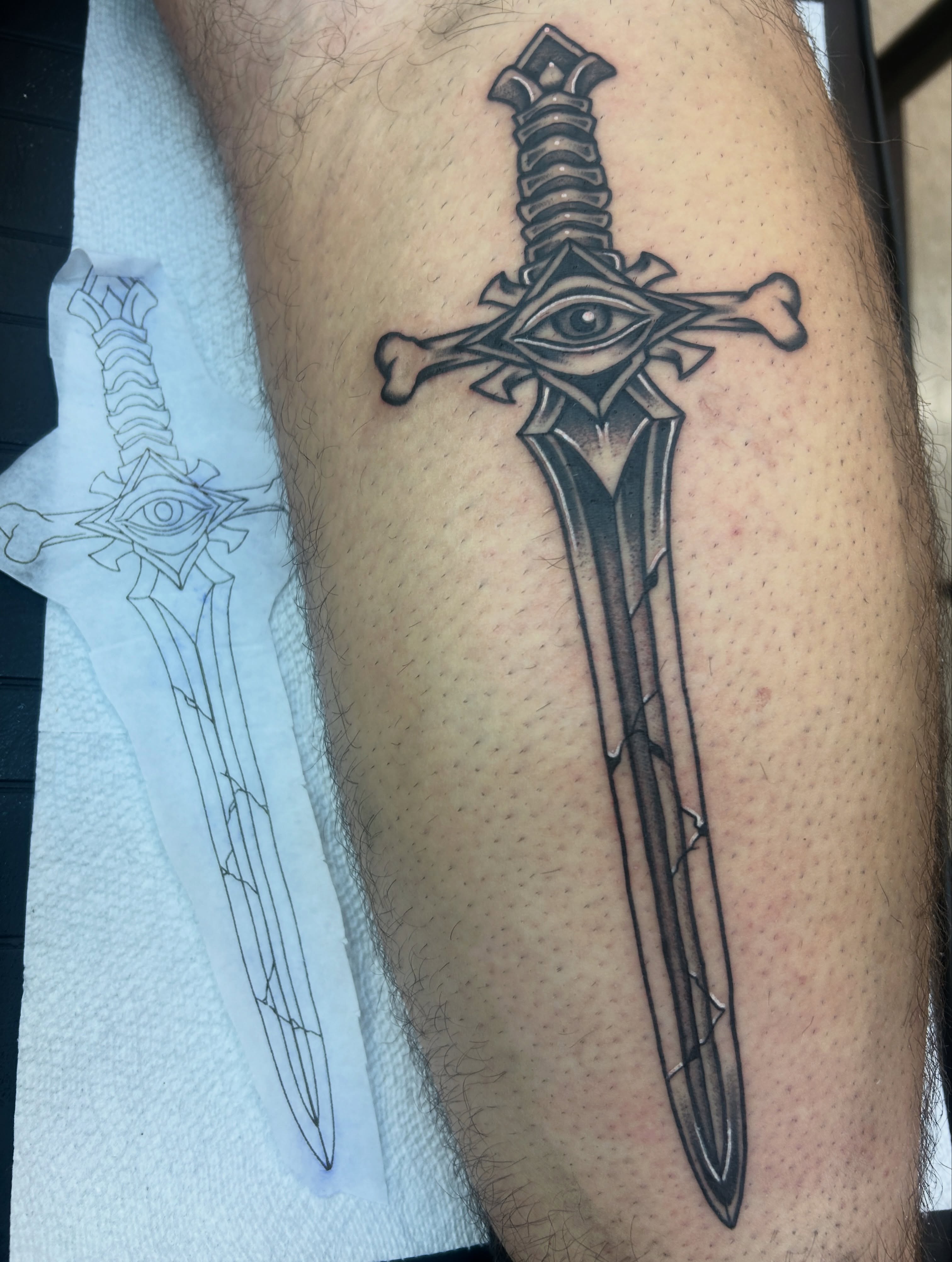 Eye and sword geometric tattoo on the forearm by Dylan James