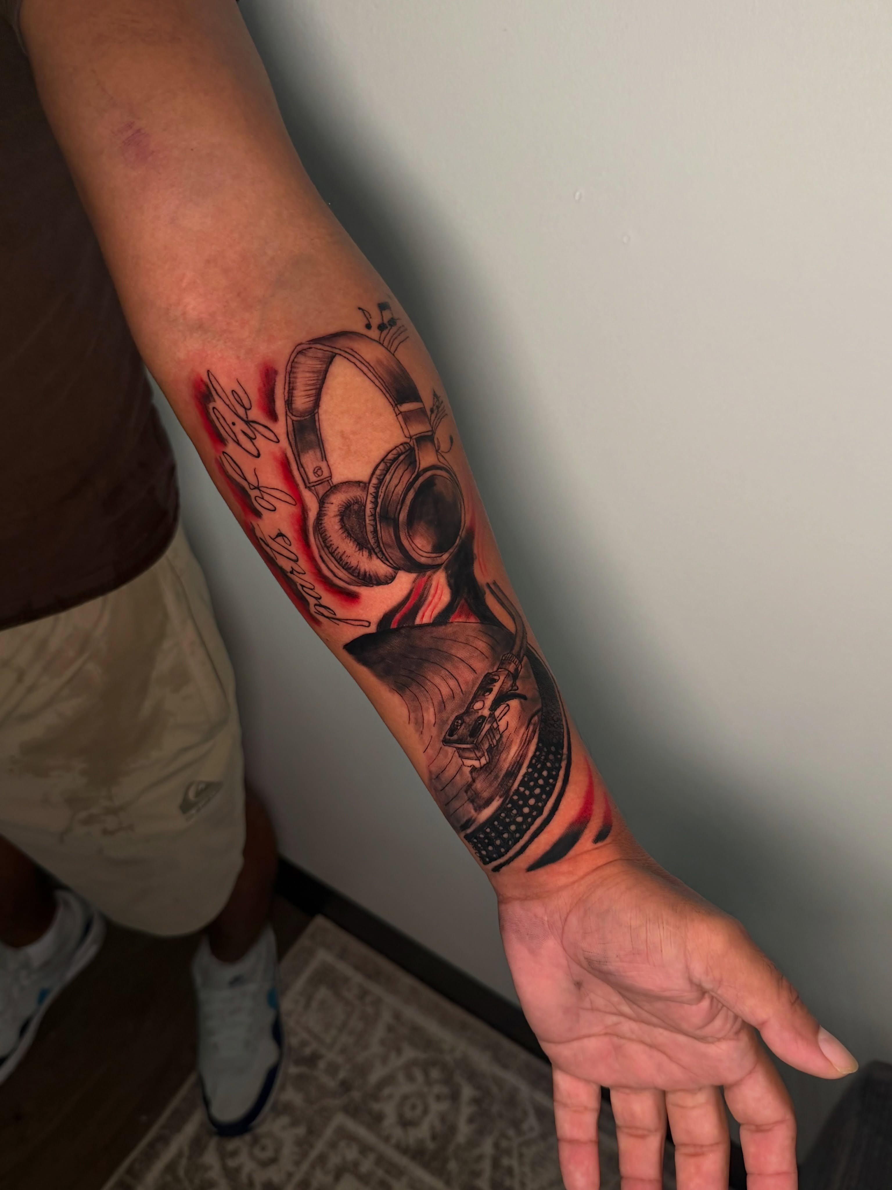 Headphones and vinyl record player realism tattoo on the forearm by Sebastian martinez, Memphis, Tennessee