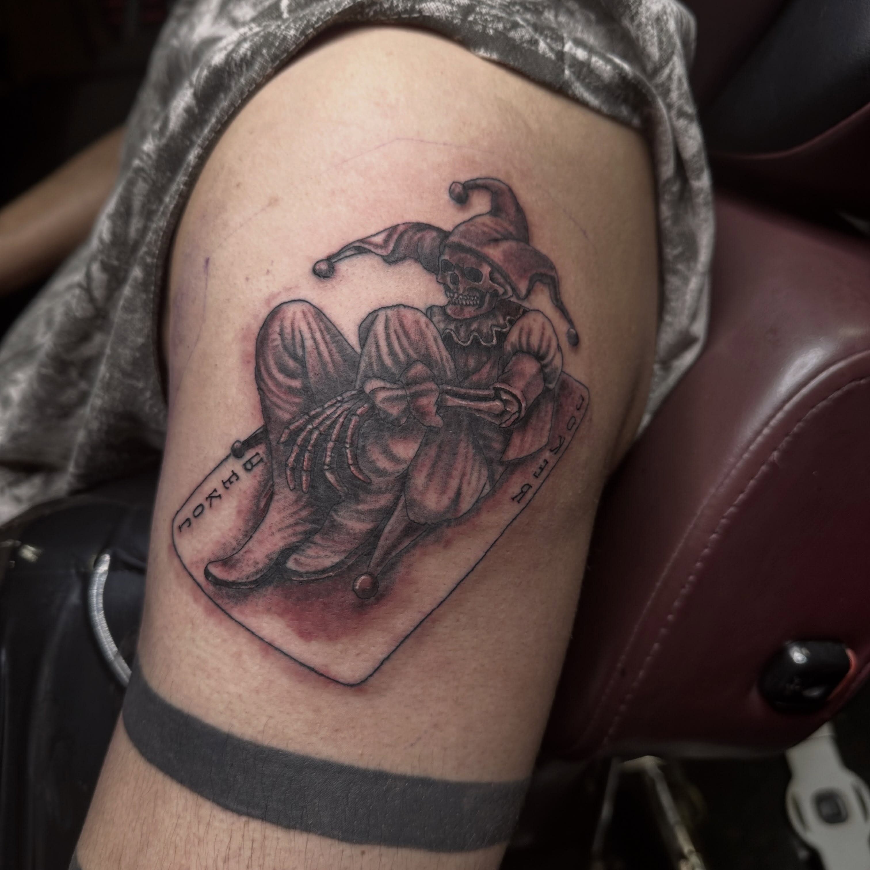 Jester skeleton black and grey tattoo on the thigh by Red (Owner), Brooklyn, New York