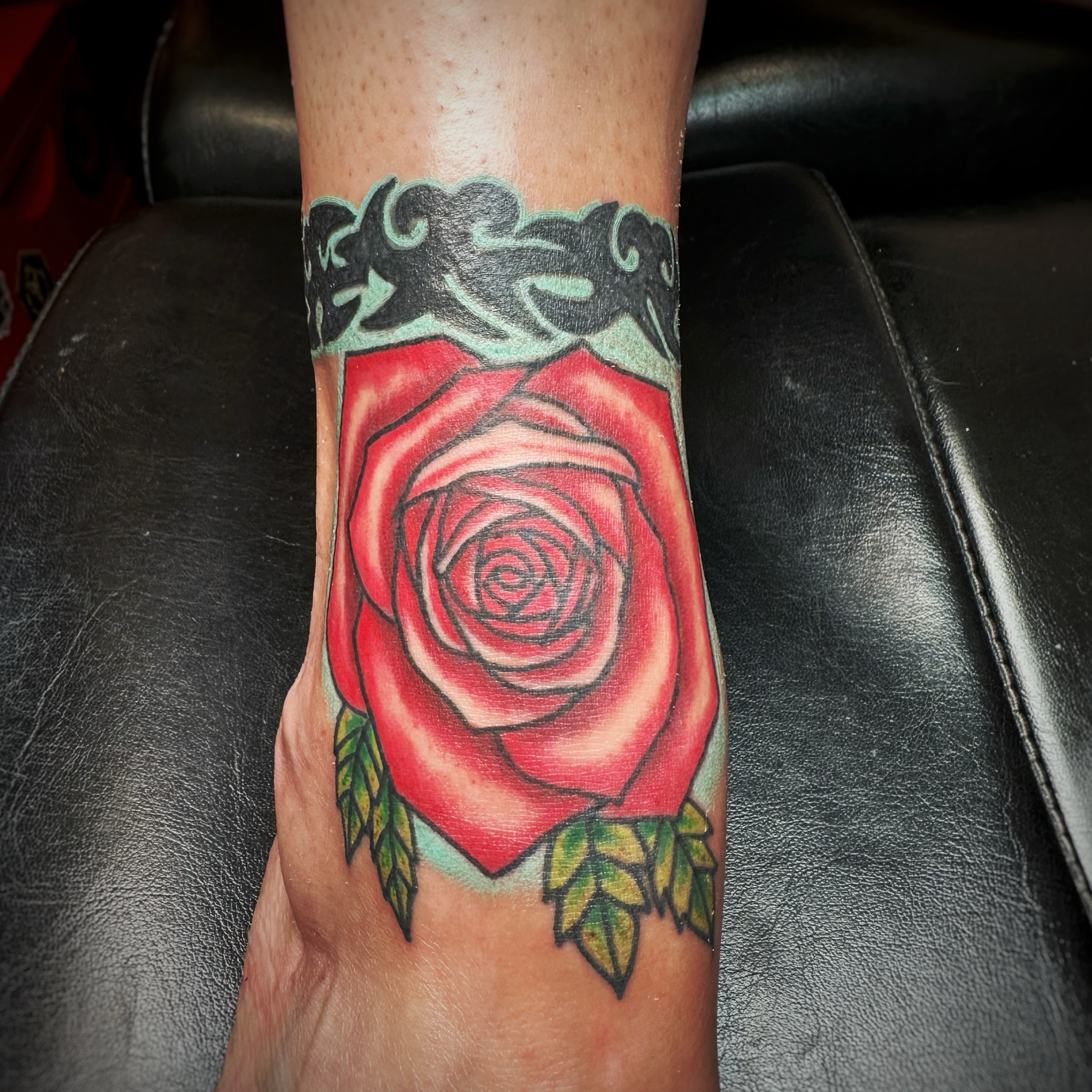 Red rose American traditional tattoo on the forearm by Anthony Guido