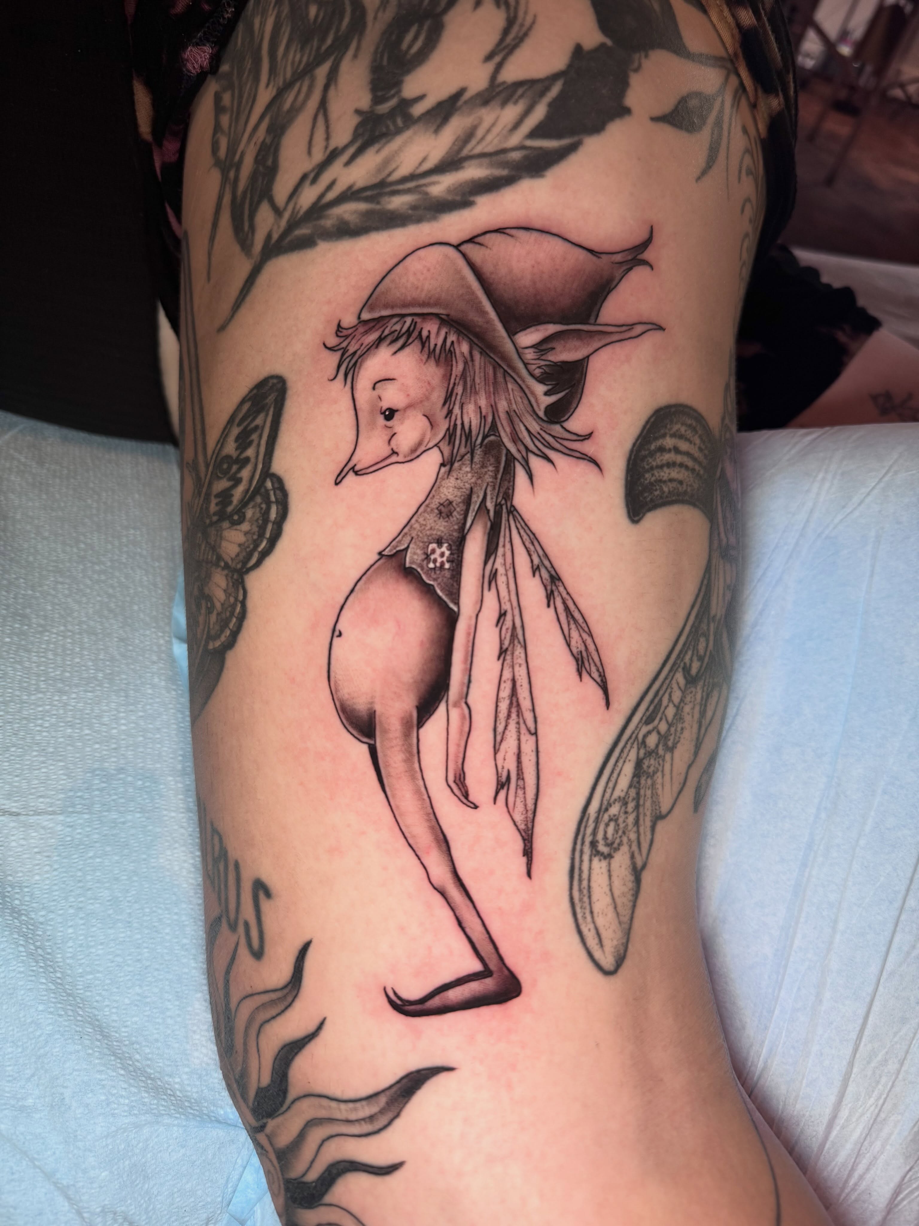 Elf-like creature black and grey tattoo on the forearm by Gabrielle Mack