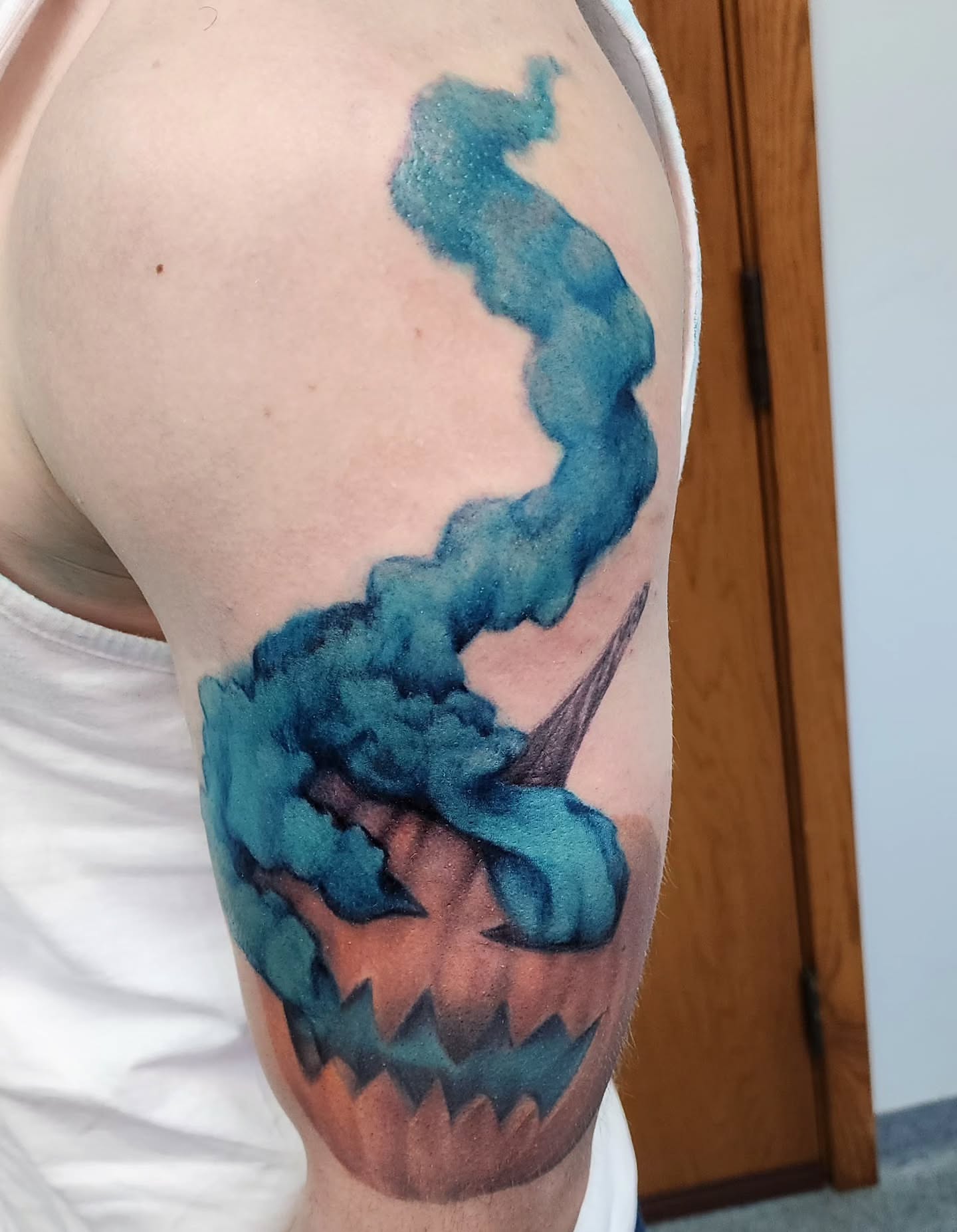 Smoking pumpkin watercolor tattoo on the forearm by Katie Palmer