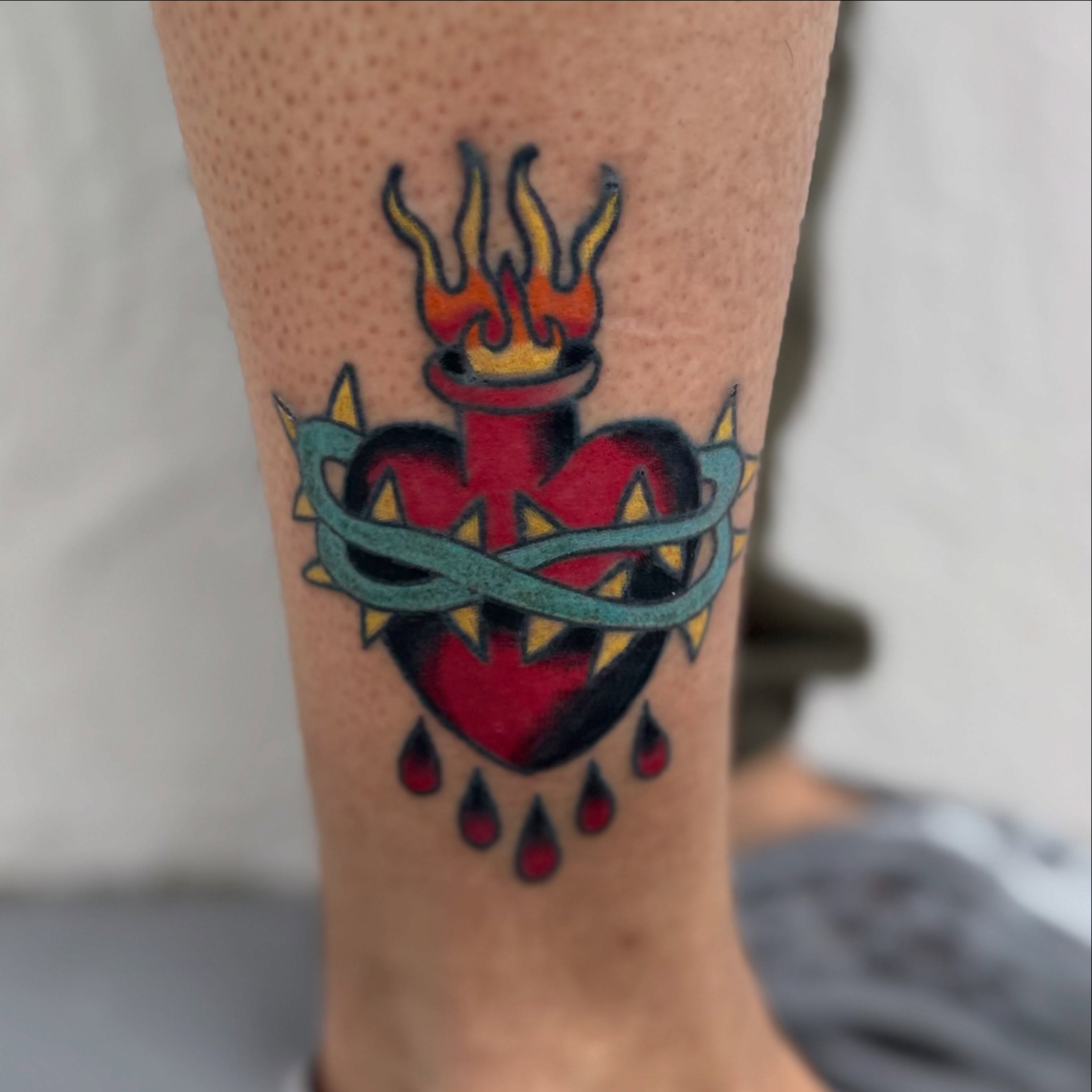 Heart with flames American traditional tattoo on the calf by Camilo