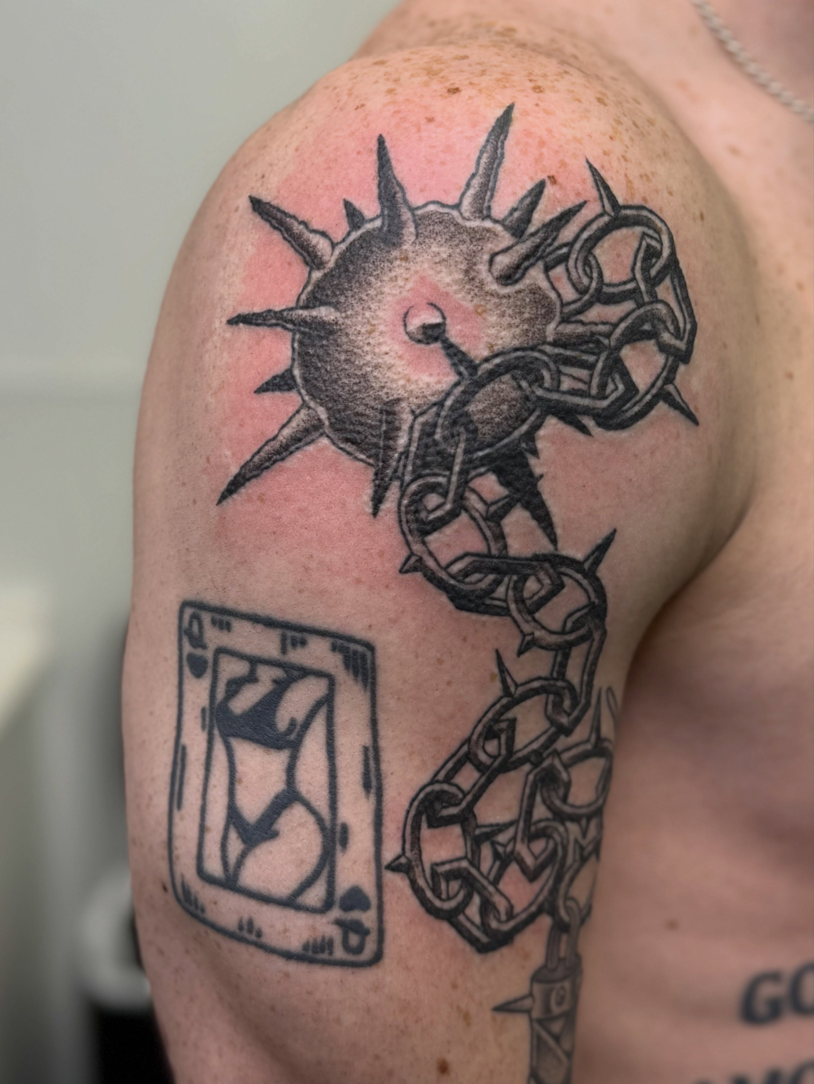 Spiked ball and chain black and grey tattoo on the shoulder by Austin Poliszuk, Minneapolis, Minnesota