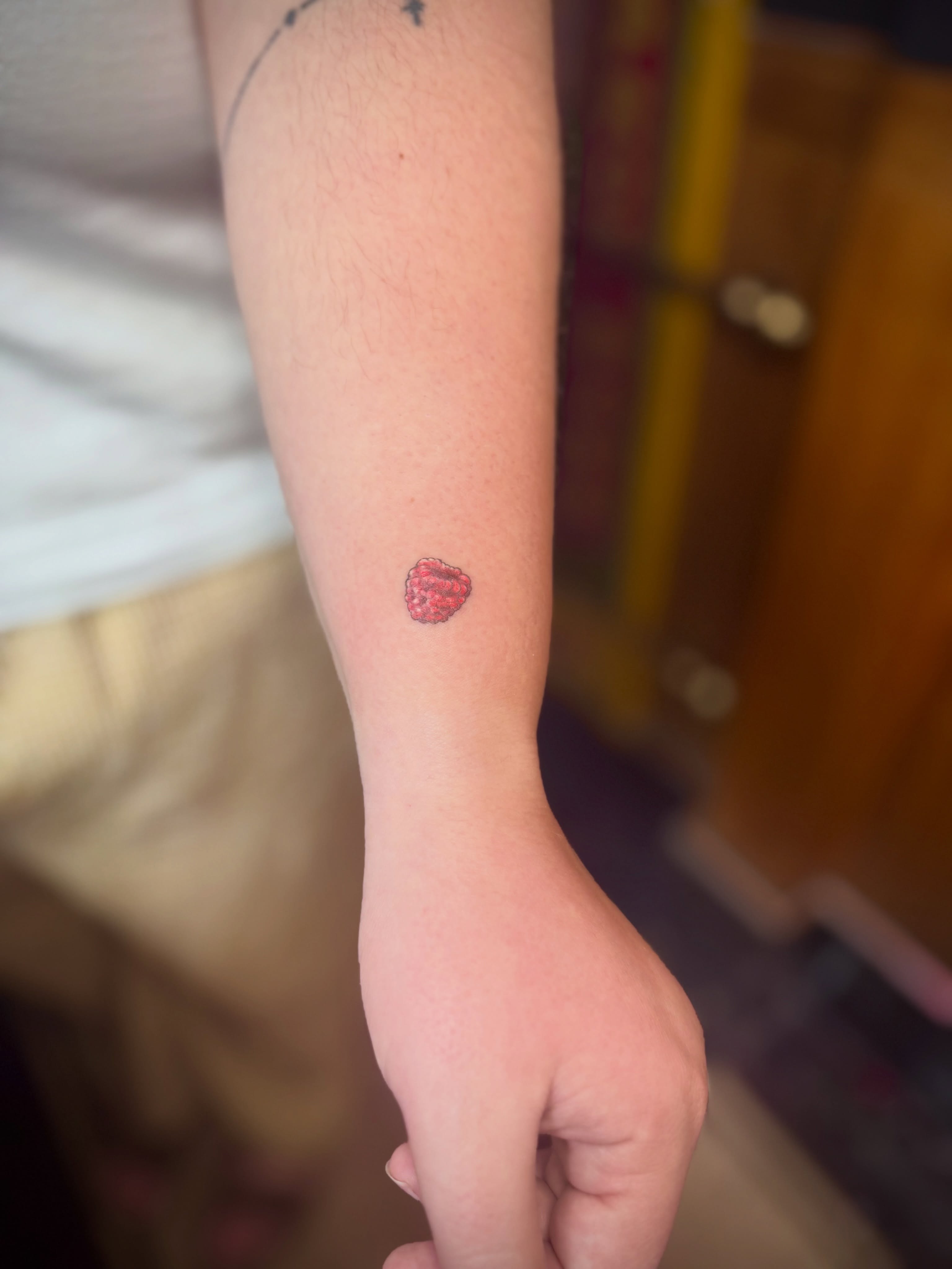 Raspberry dotwork tattoo on the forearm by Kylie Allen