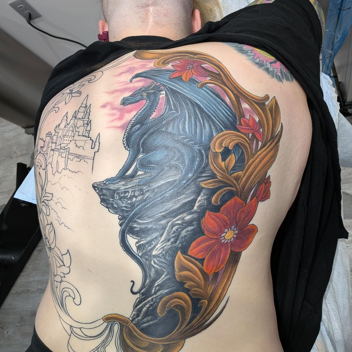 Dragon and flowers realism tattoo on the back by Chris Bowen