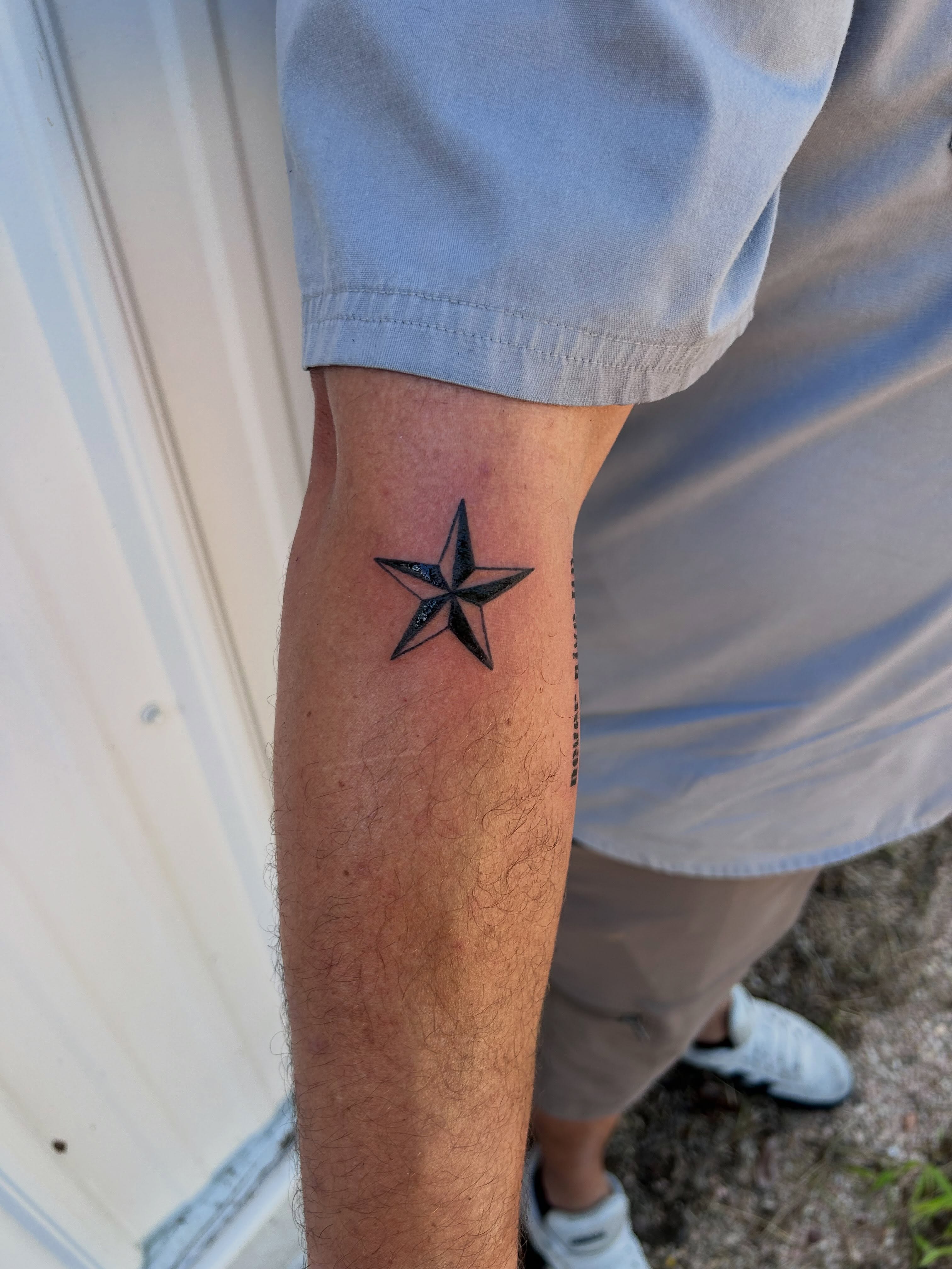 Star black and grey tattoo on the forearm by Miss Katie