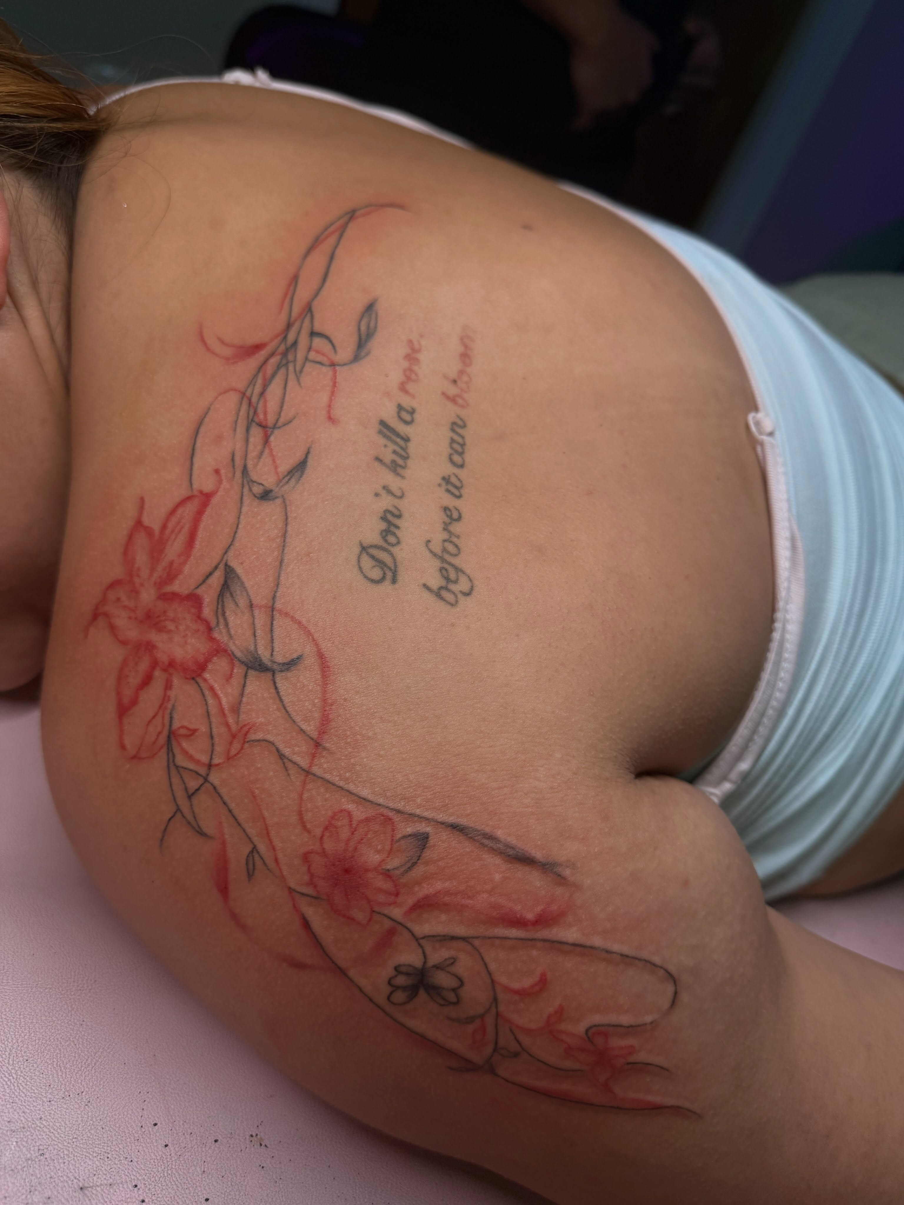 Flowers and quote new school tattoo on the shoulder by Tattoos by Santos