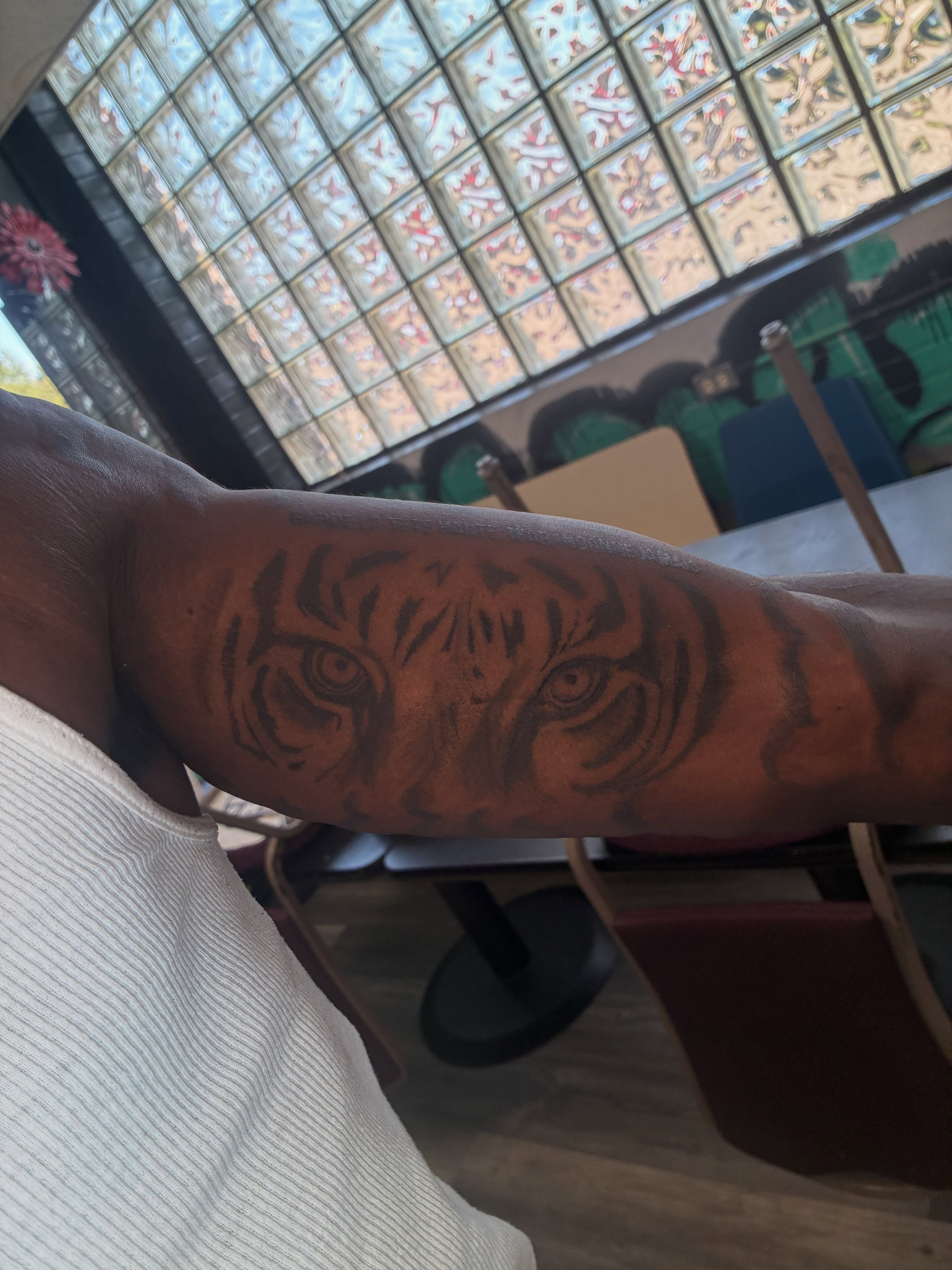 Tiger eyes black and grey tattoo on the forearm by Trae