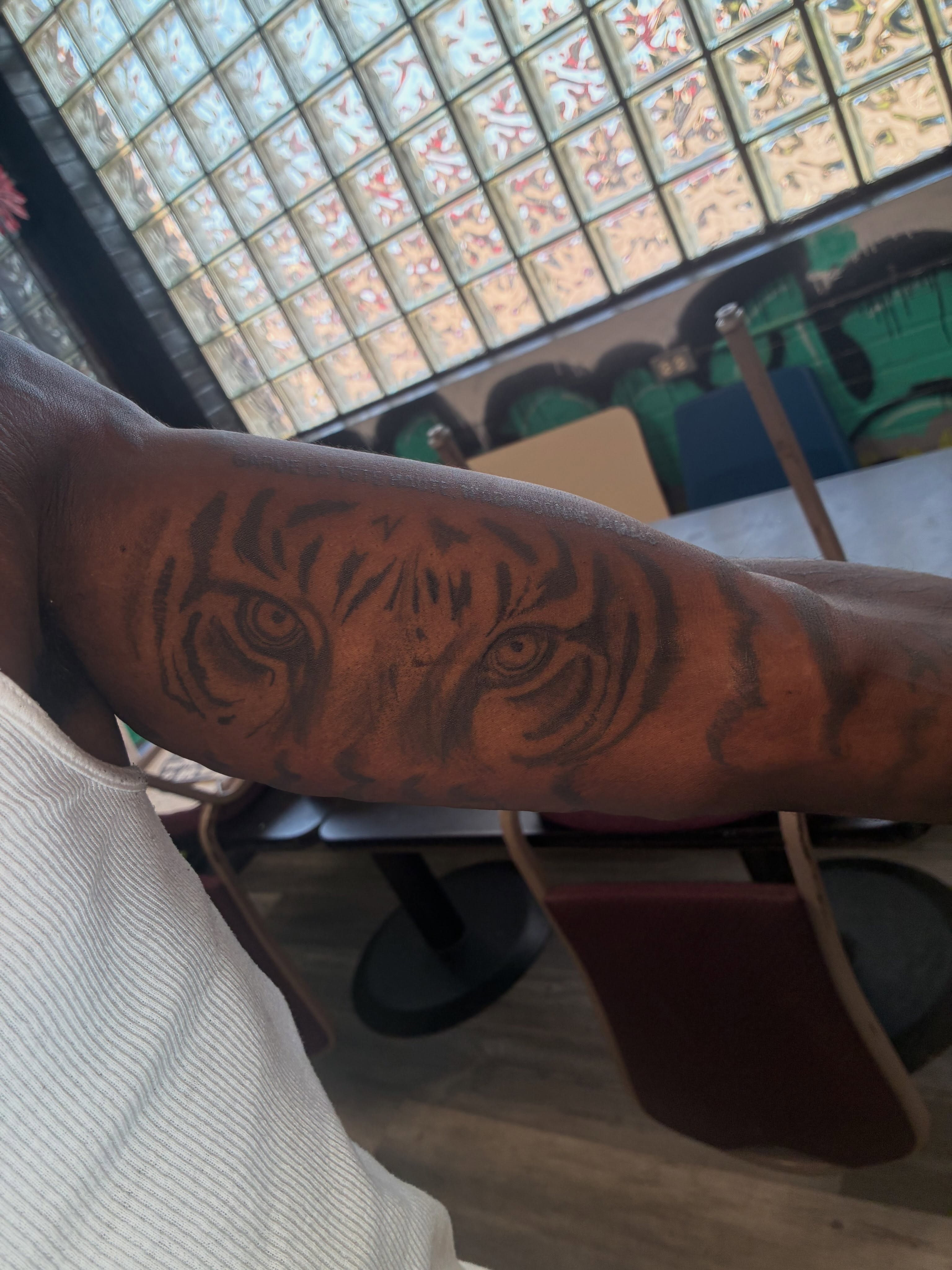 Tiger eyes realism tattoo on the forearm by Trae