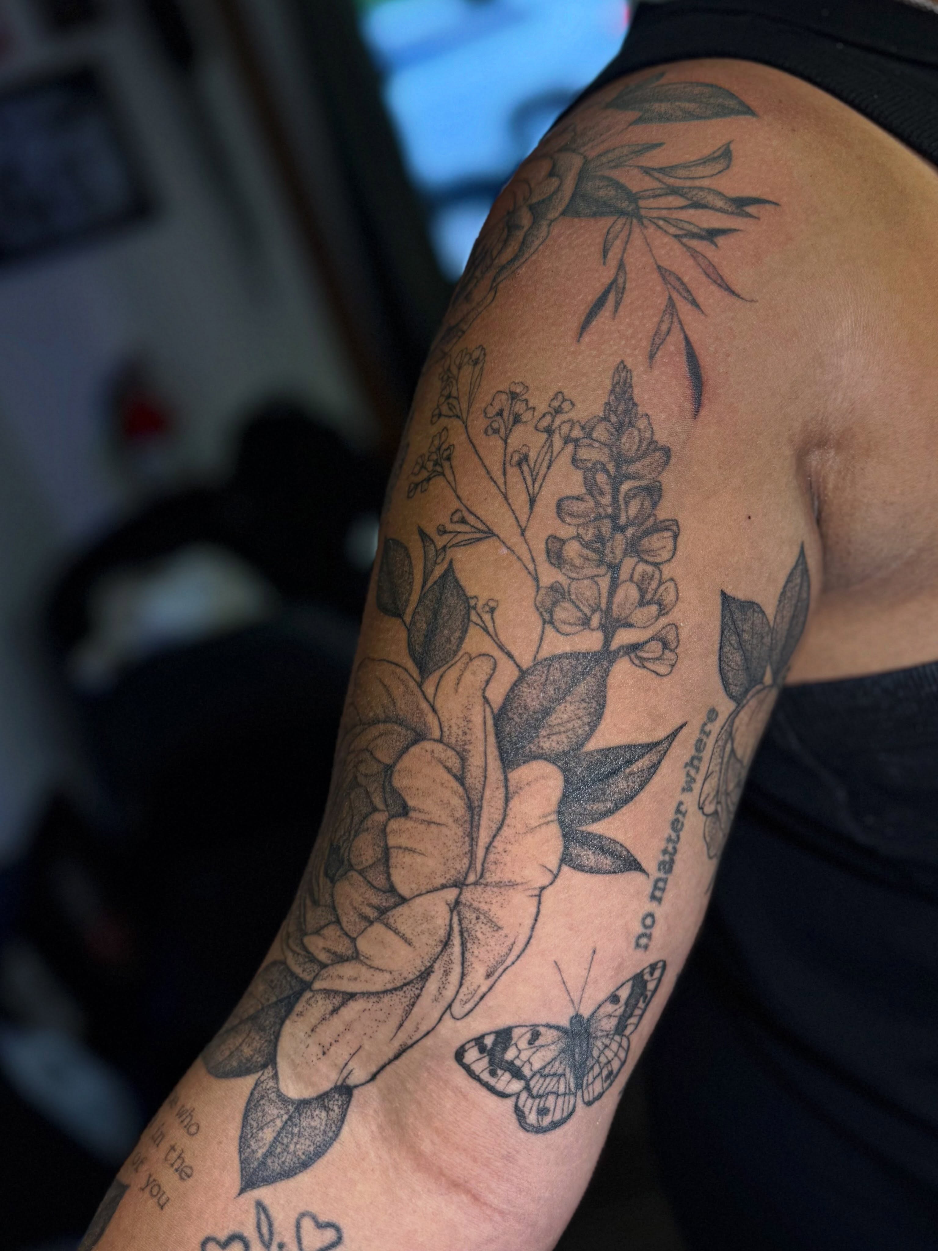 Floral arrangement with butterfly realism tattoo on the upper arm by βπ¬π―π’πΆ