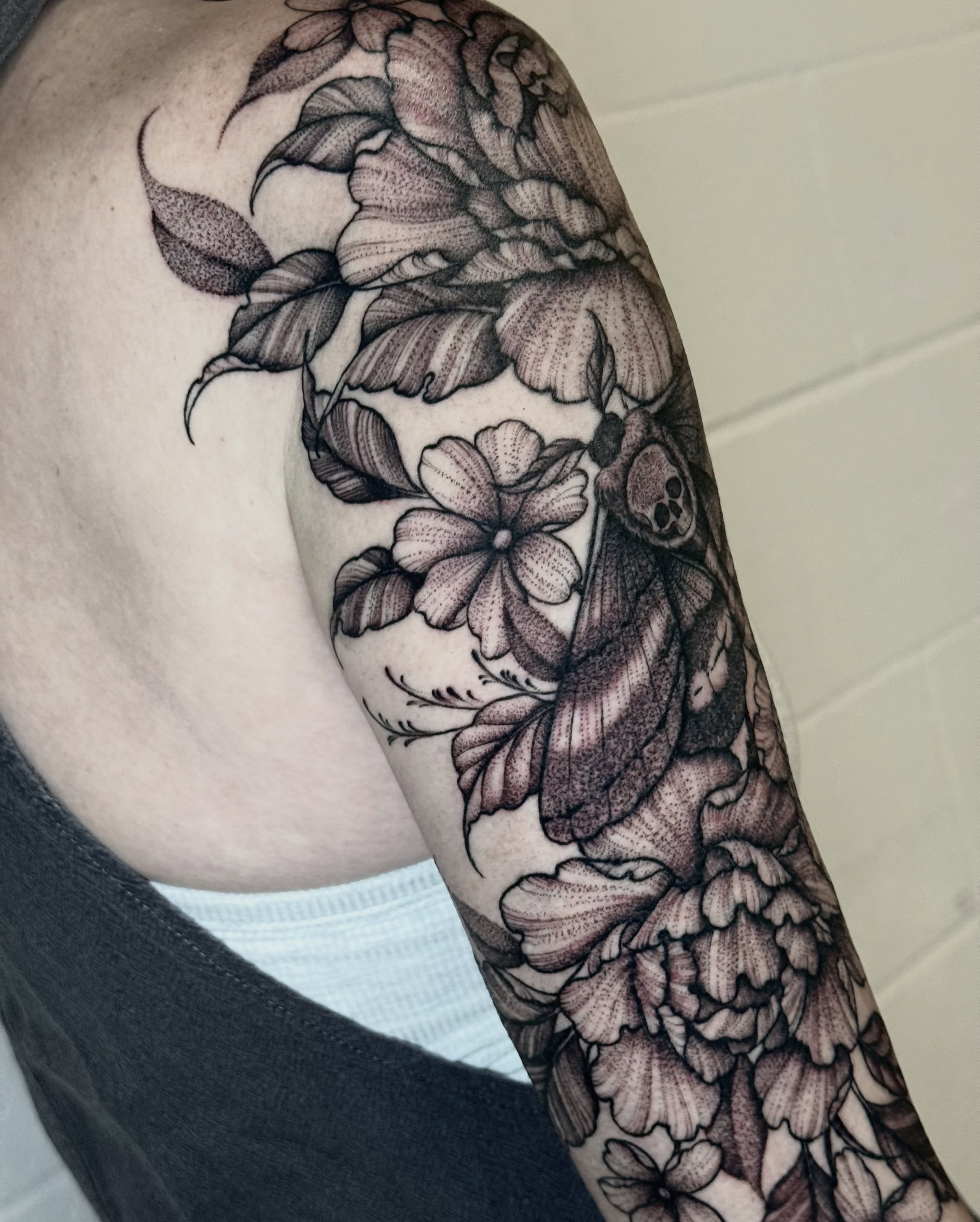 Flowers and moth dotwork tattoo on the upper arm by ℳ𝒾𝓇𝓉𝒽𝒶 𝒯ℴ𝓇𝓇ℯ𝓈, San Diego, California