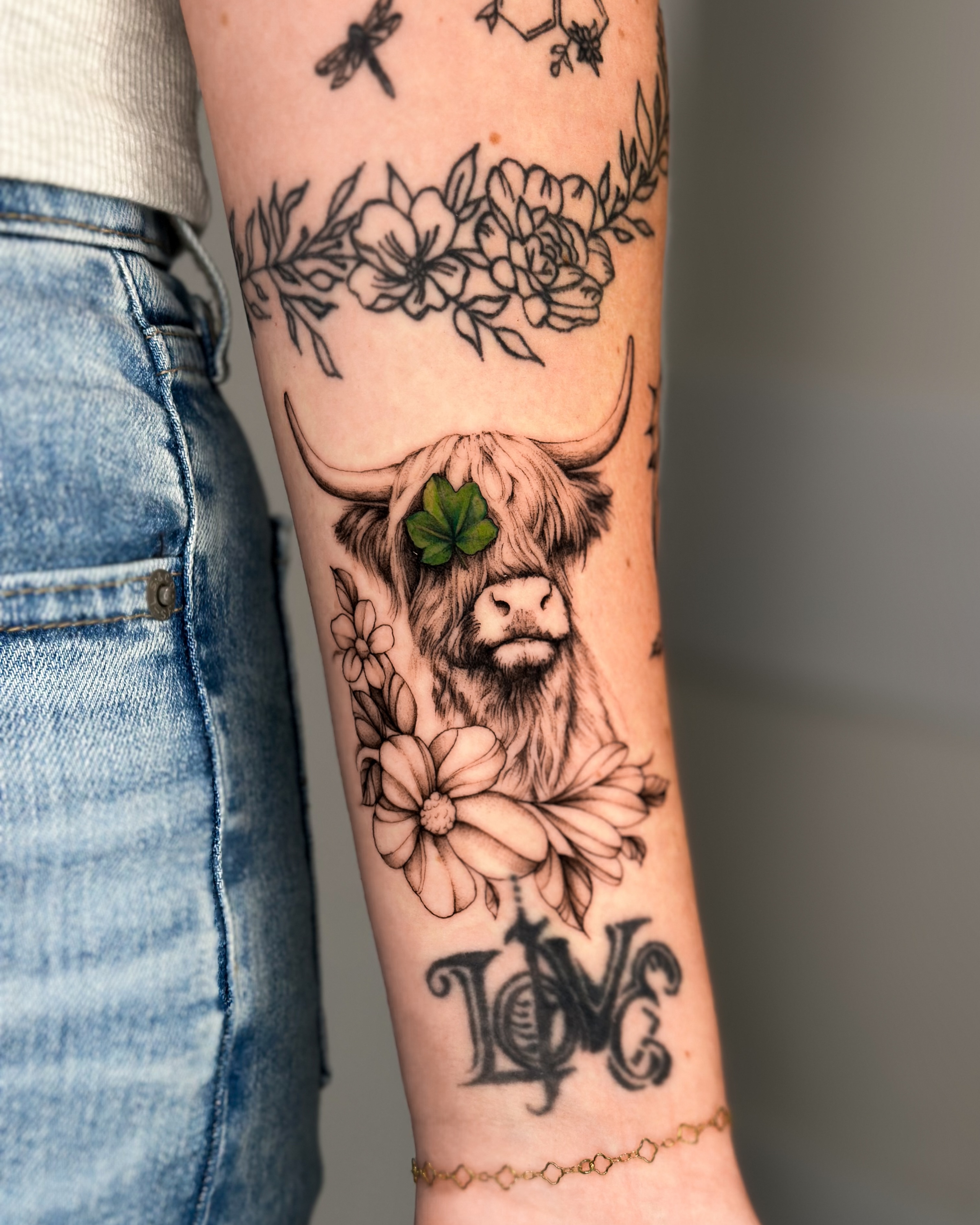 Highland cow black and grey tattoo on the forearm by Lauren