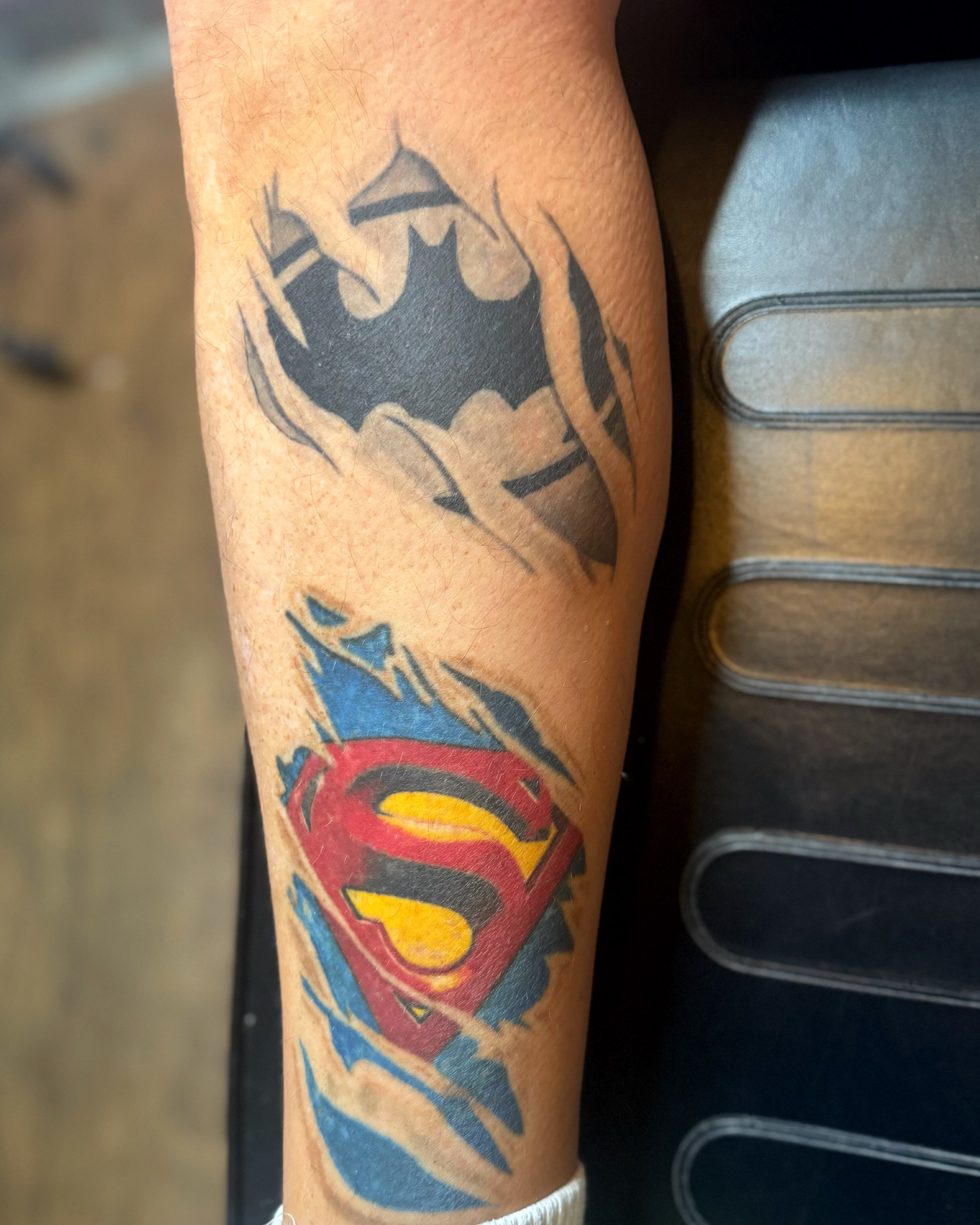 Batman and superman American traditional tattoo on the forearm by Chris Adkins Tattoos, Chattanooga, Tennessee