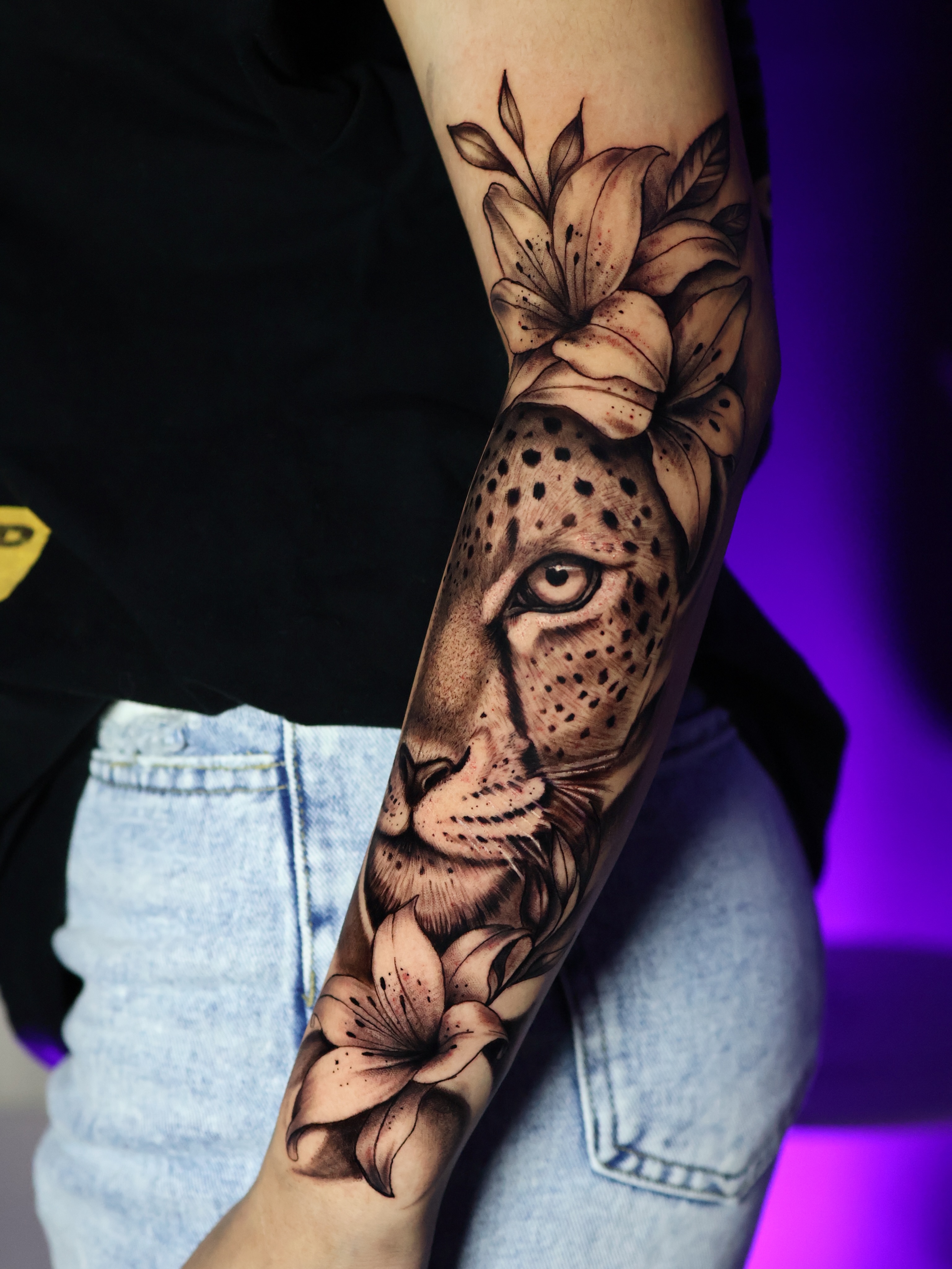 Cheetah and flowers realism tattoo on the forearm by German Patiño.