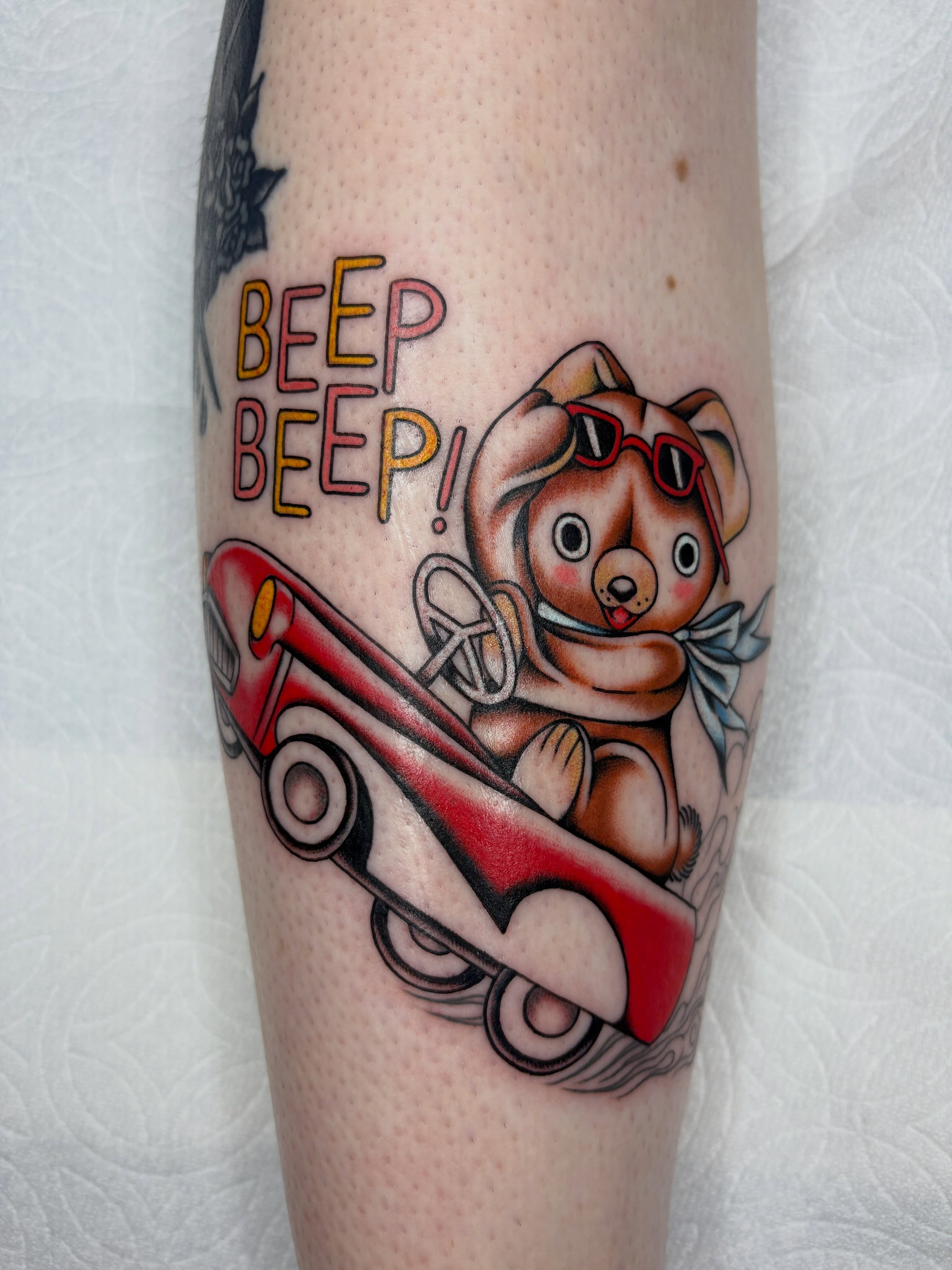 Bear driving car American traditional tattoo on the forearm by Nori