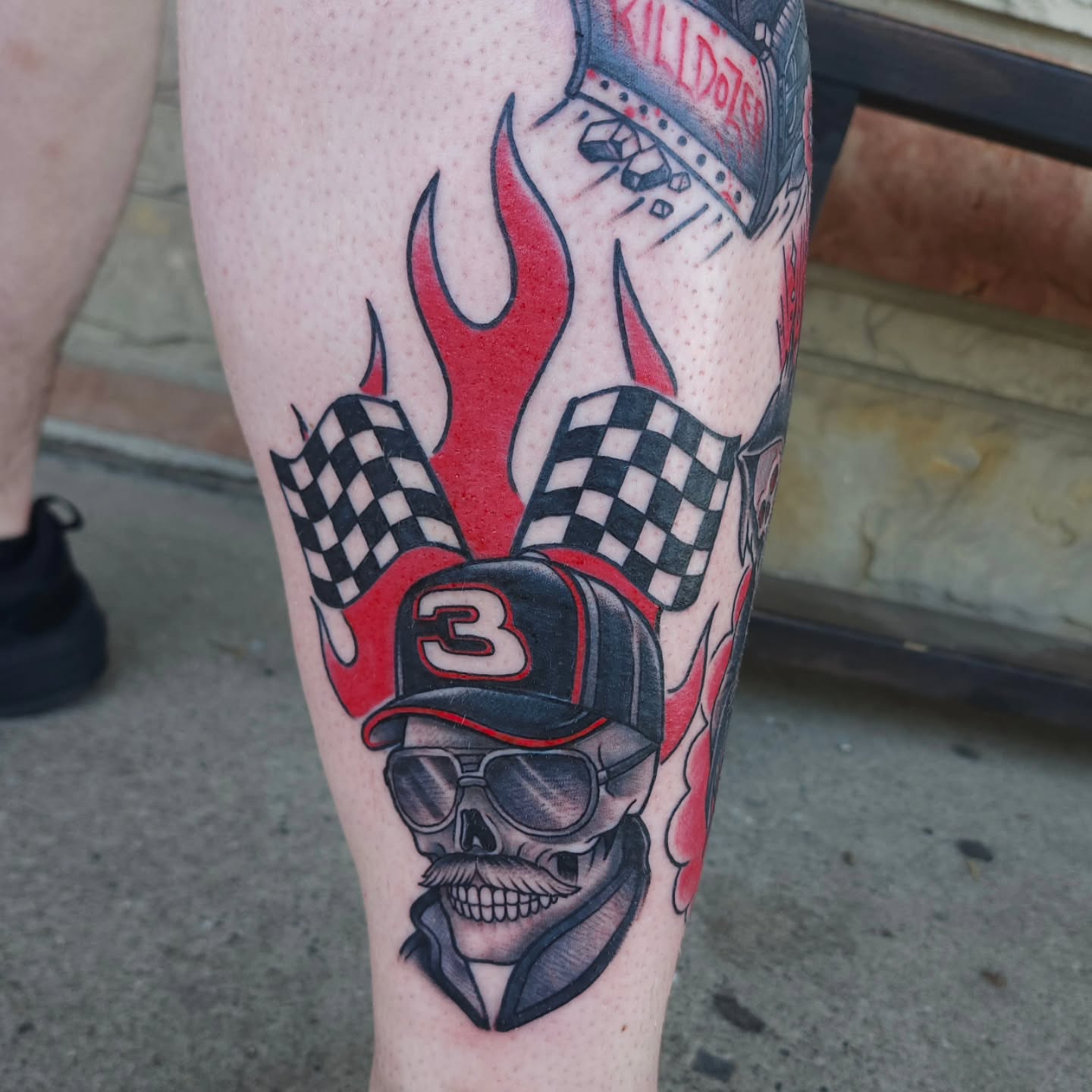 Racing skull American traditional tattoo on the calf by Chris Wodarski