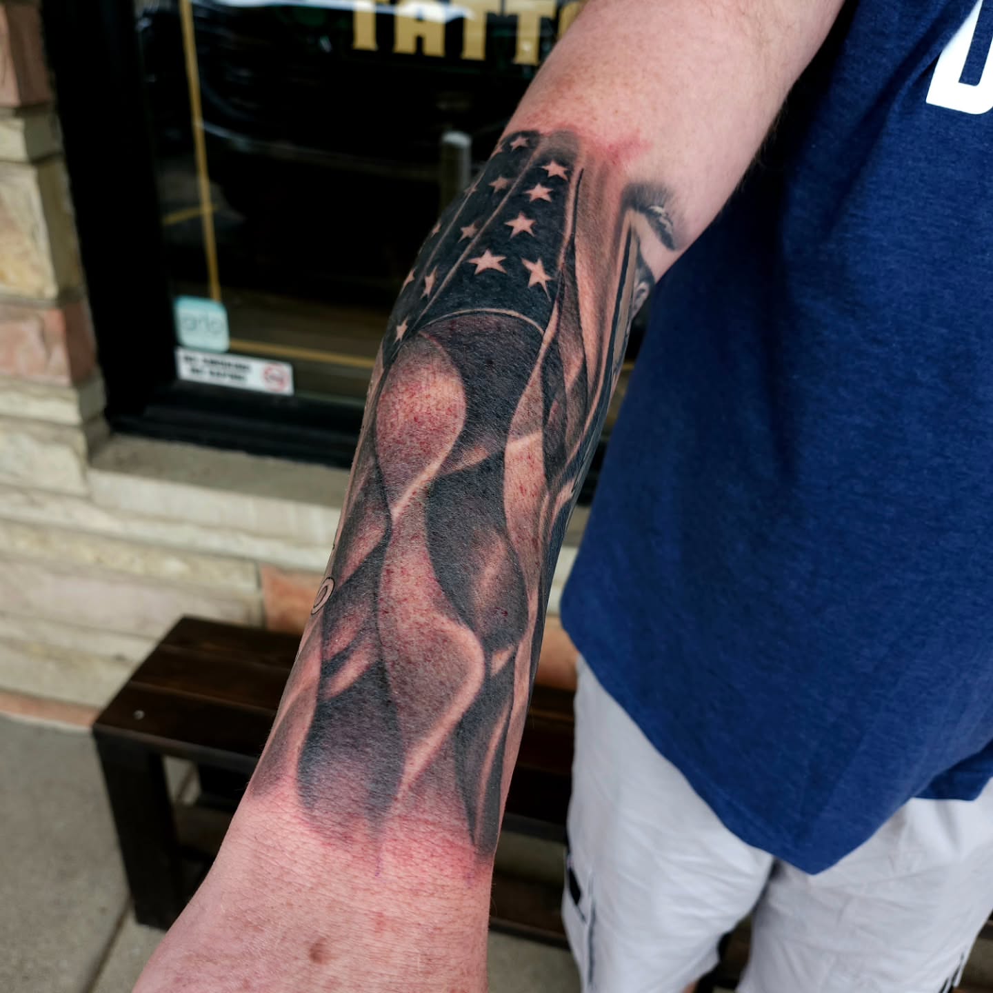 American flag realism tattoo on the forearm by Chris Wodarski