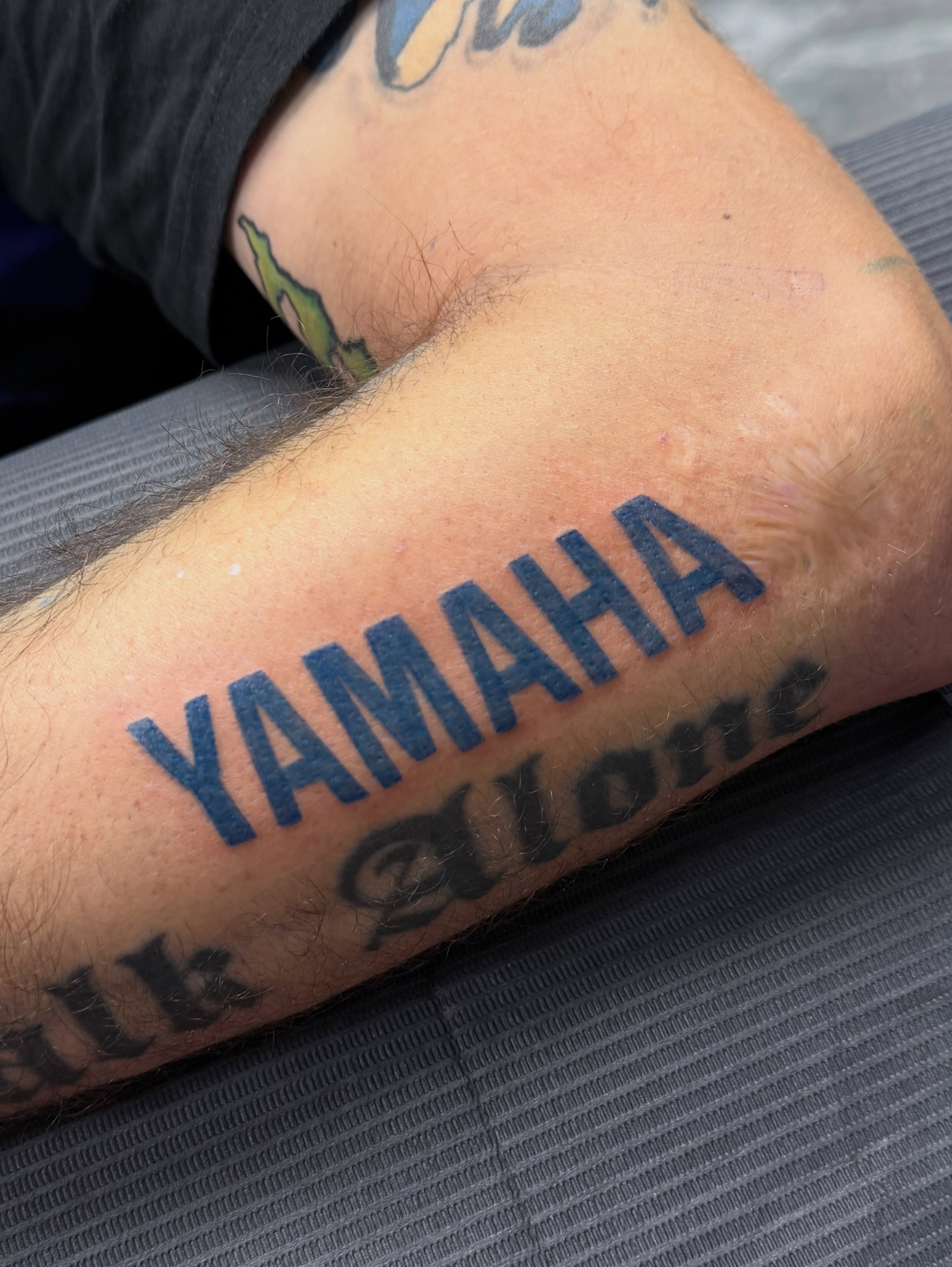 Yamaha lettering script tattoo on the forearm by Jennifer Flores