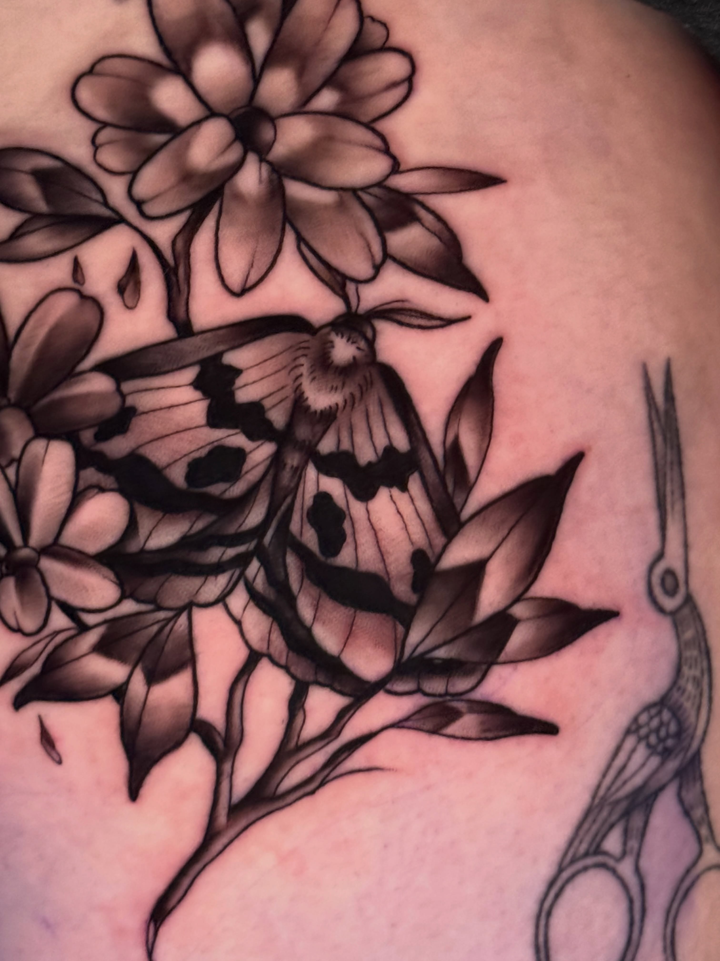 Butterfly and flowers black and grey tattoo on the shoulder by tori 🫶🏻