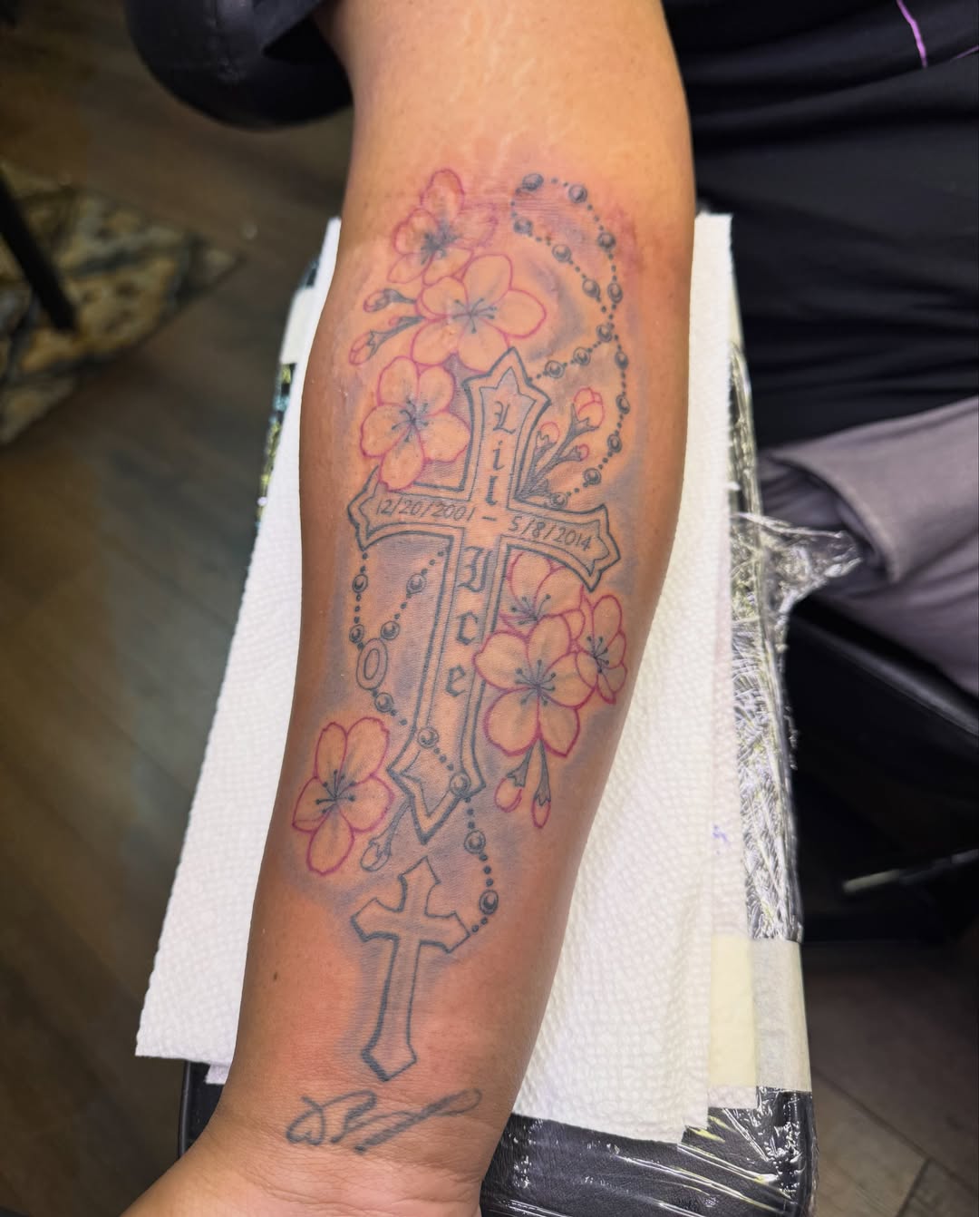 Cross with flowers American traditional tattoo on the forearm by Christian Goines, Memphis, Tennessee