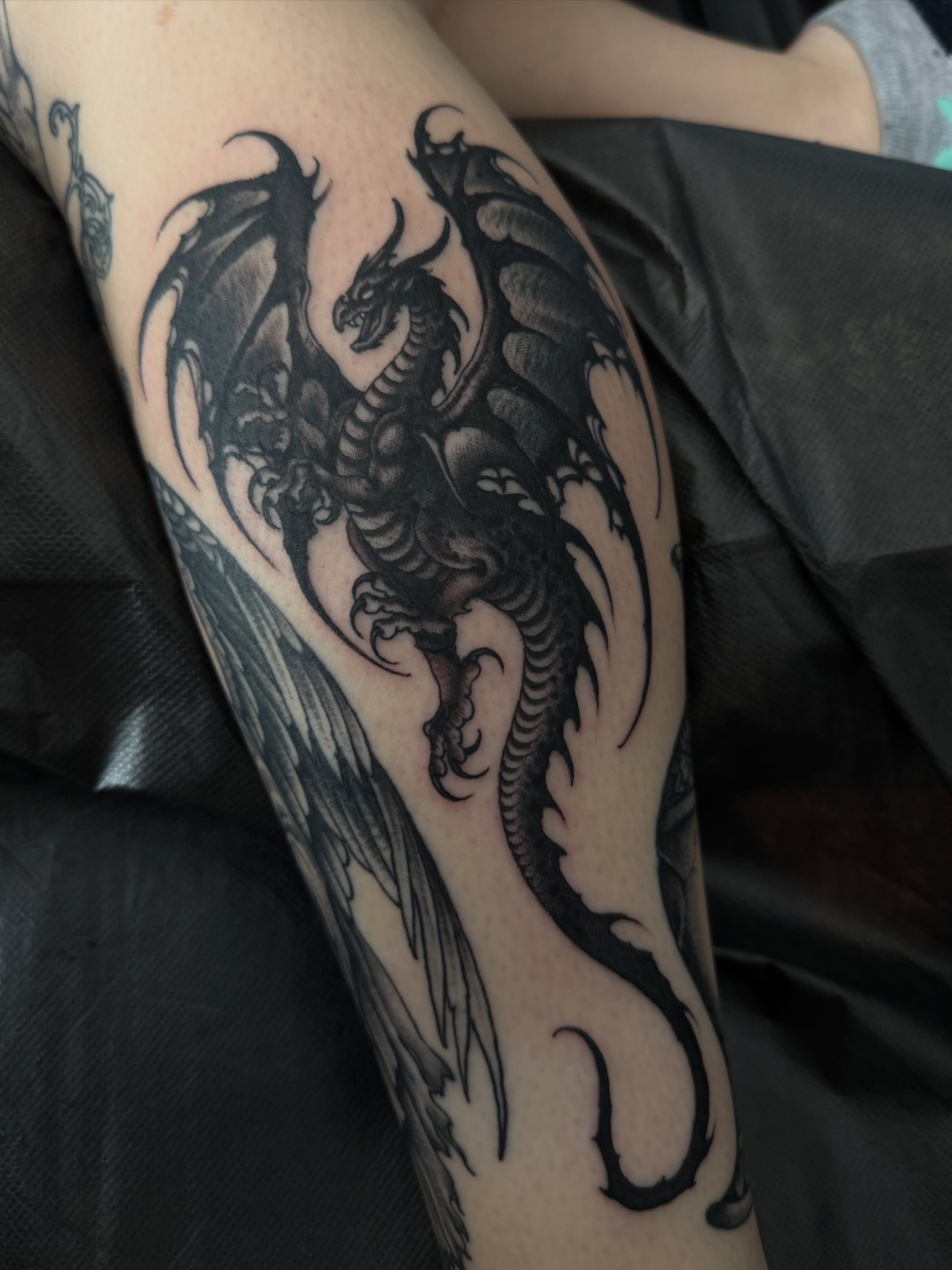 Dragon black and grey tattoo on the forearm by Nicholas Tidler