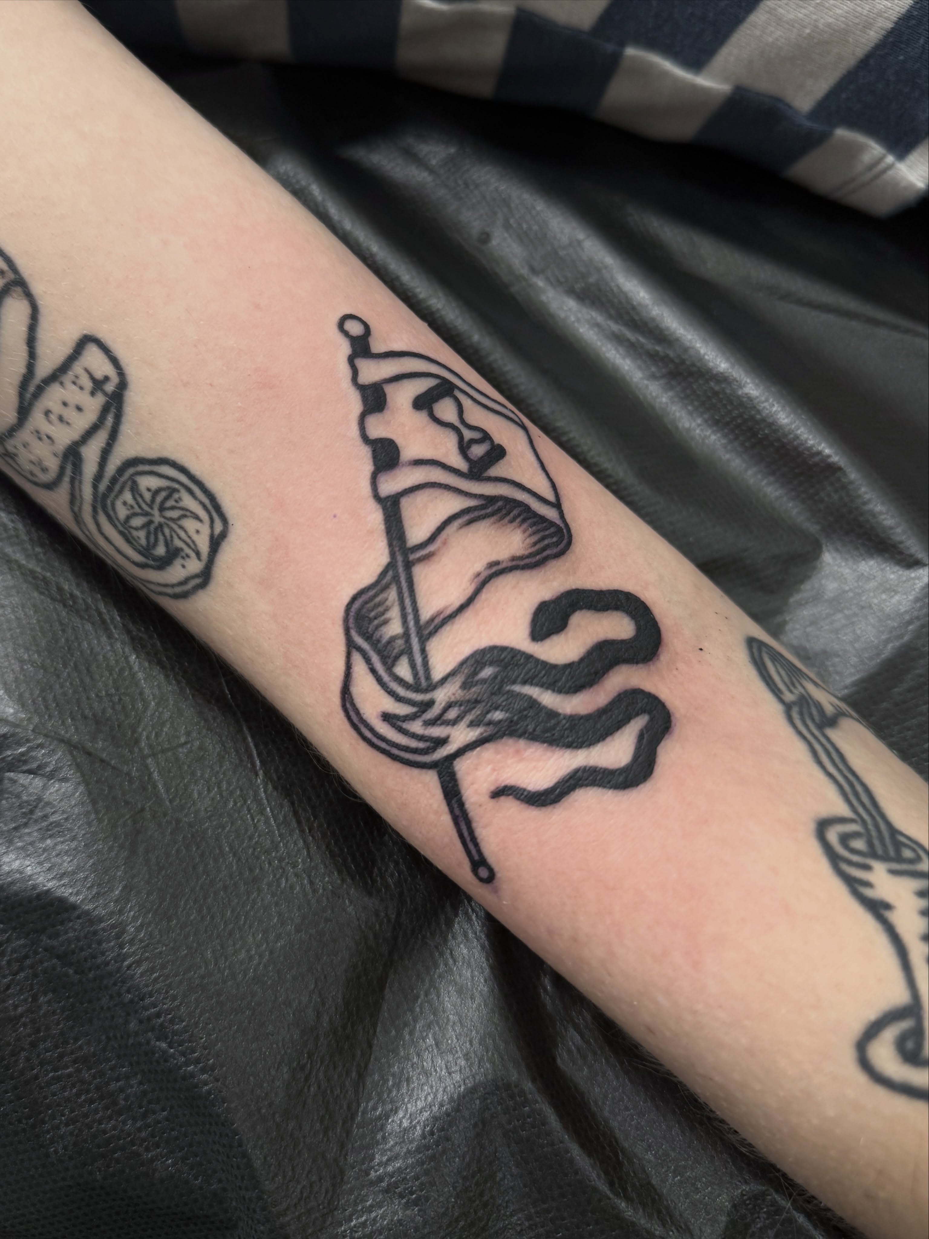 Flag and snake American traditional tattoo on the forearm by Nicholas Tidler