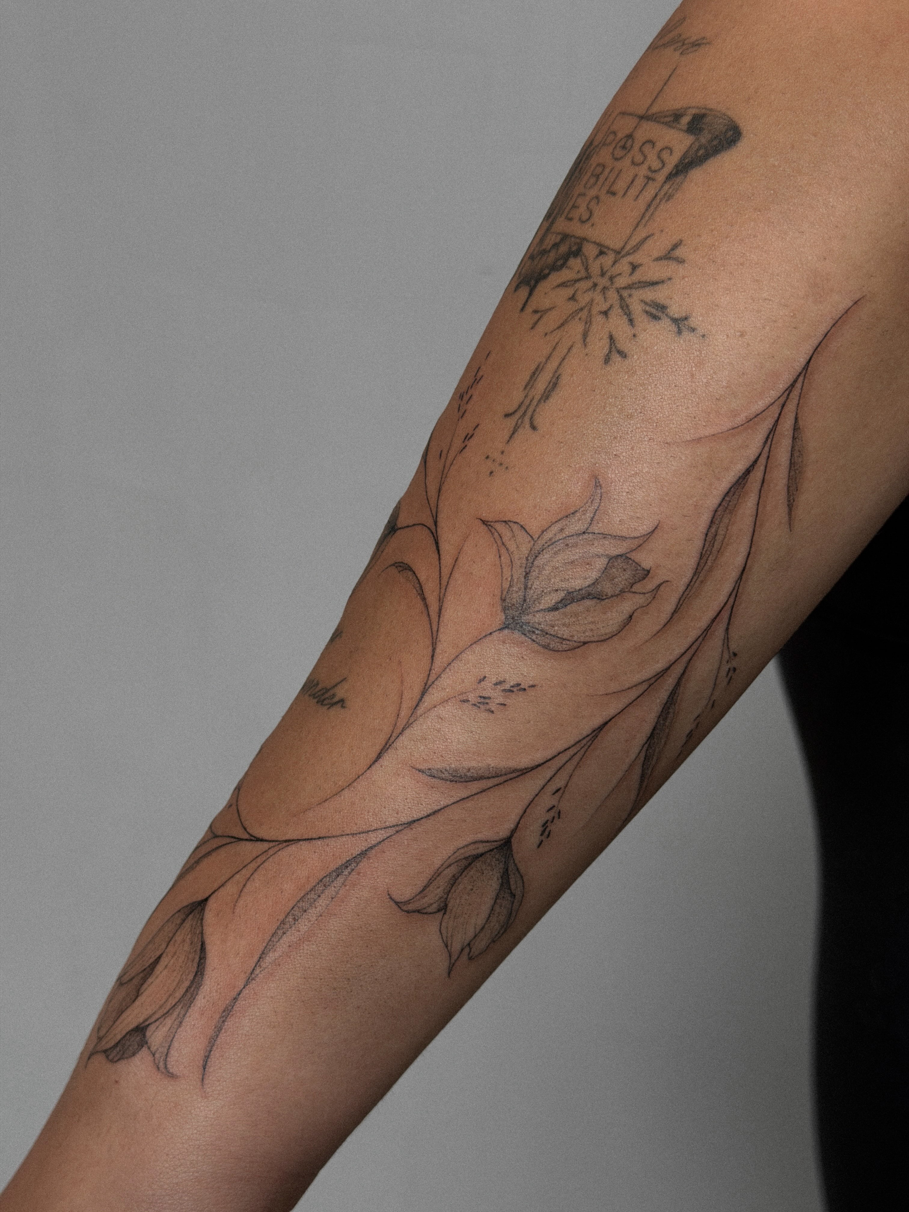 Lotus flower black and grey tattoo on the forearm by Hannah Matthews