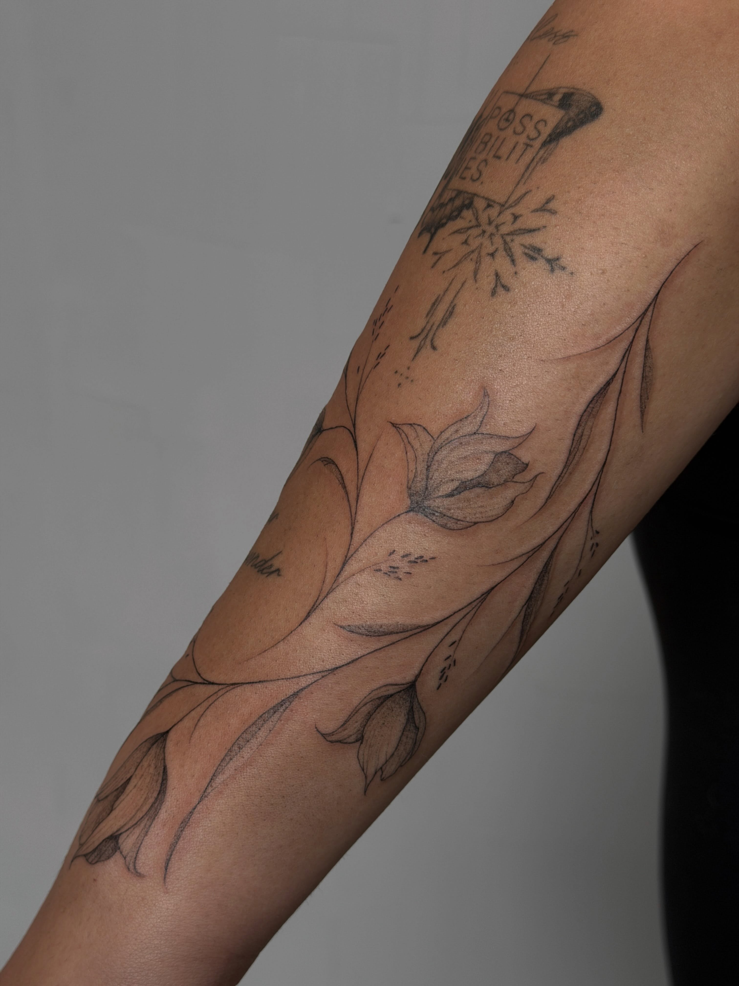 Lotus flower black and grey tattoo on the forearm by Hannah Matthews