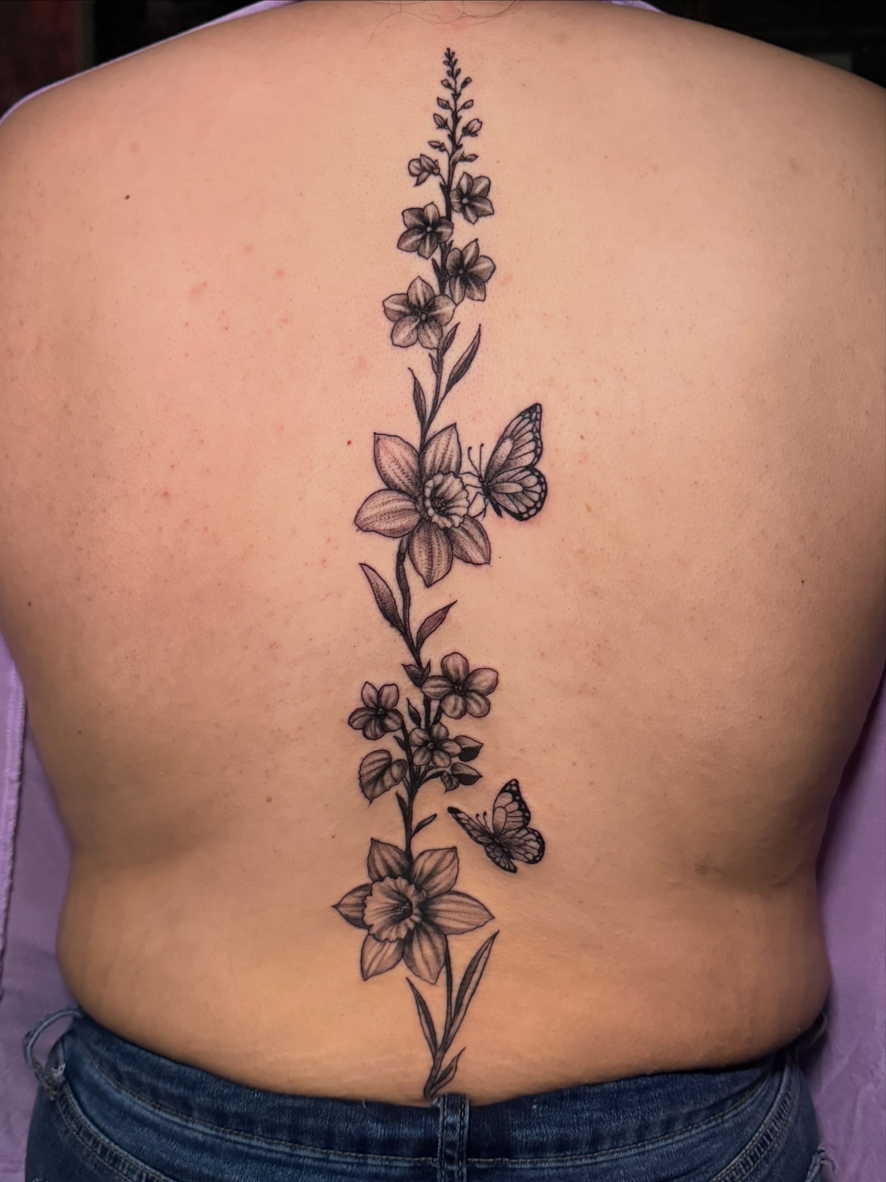 Flower and butterfly black and grey tattoo on the back by Lucky Valenzuela, Lakewood, Colorado