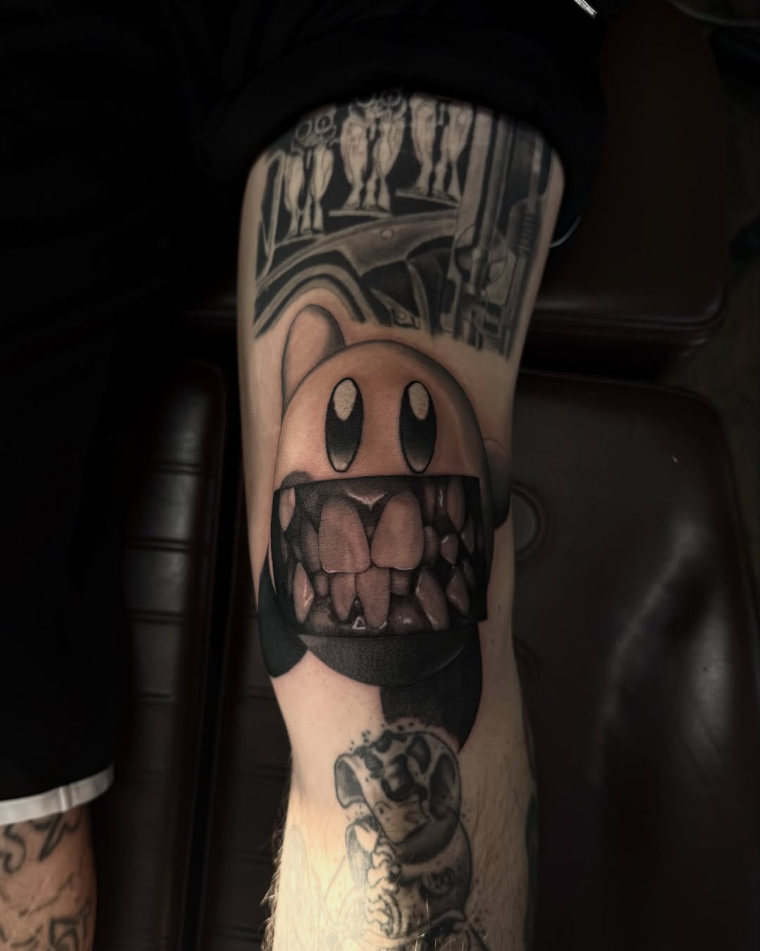 Smiling face with open mouth black and grey tattoo on the forearm by Giovanni Rodriguez, Eastpointe, Michigan