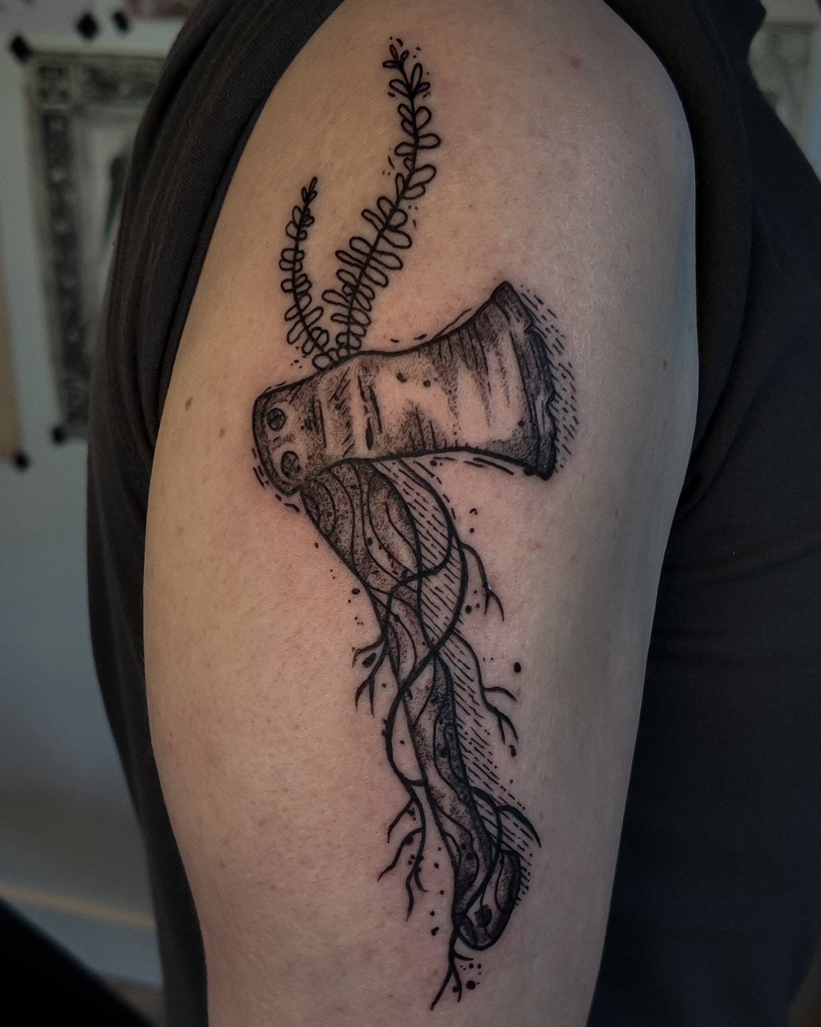 Axe with roots dotwork tattoo on the shoulder by Morgan Diann