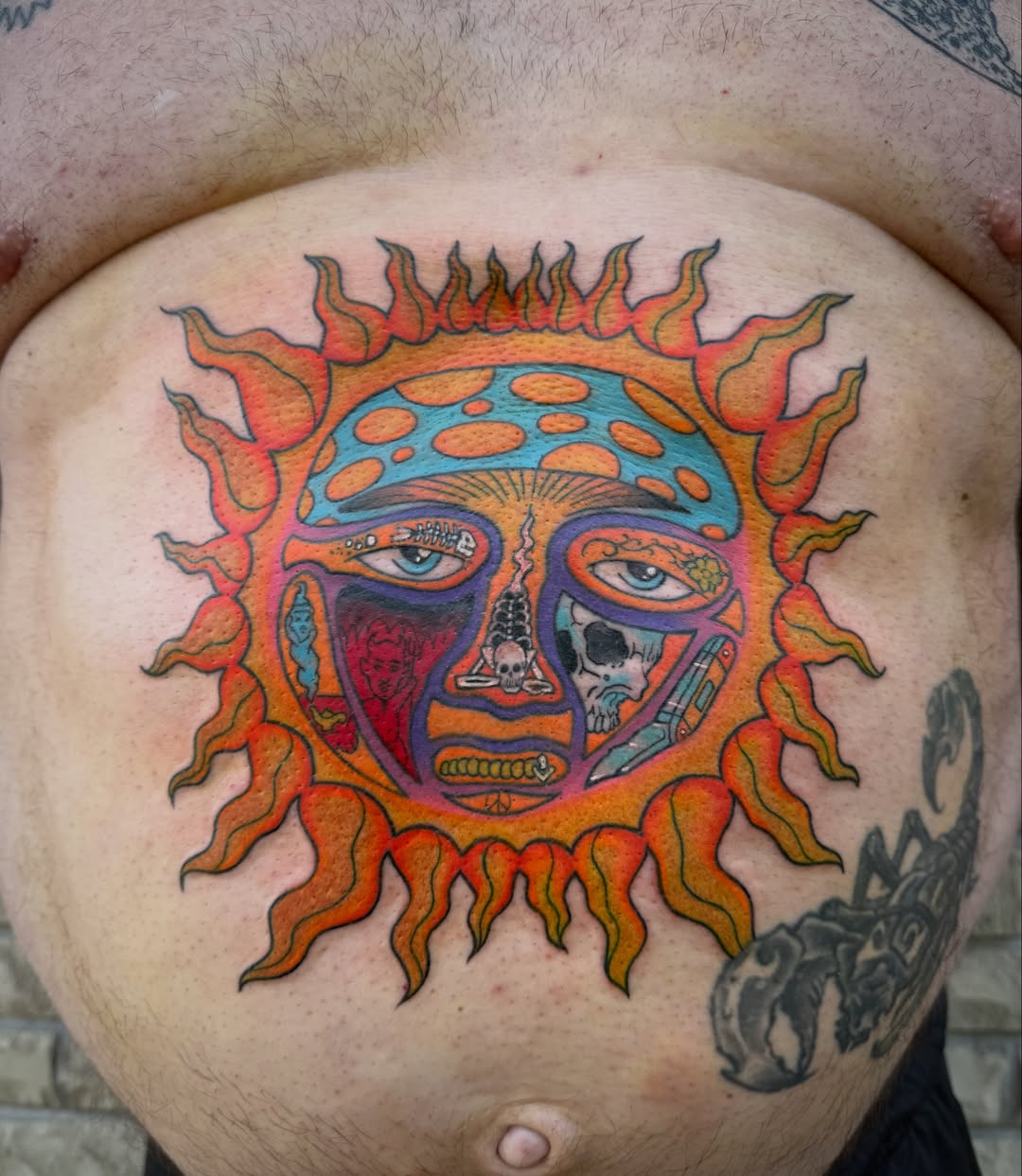 Solar face trash polka tattoo on the torso by Abby Hofman