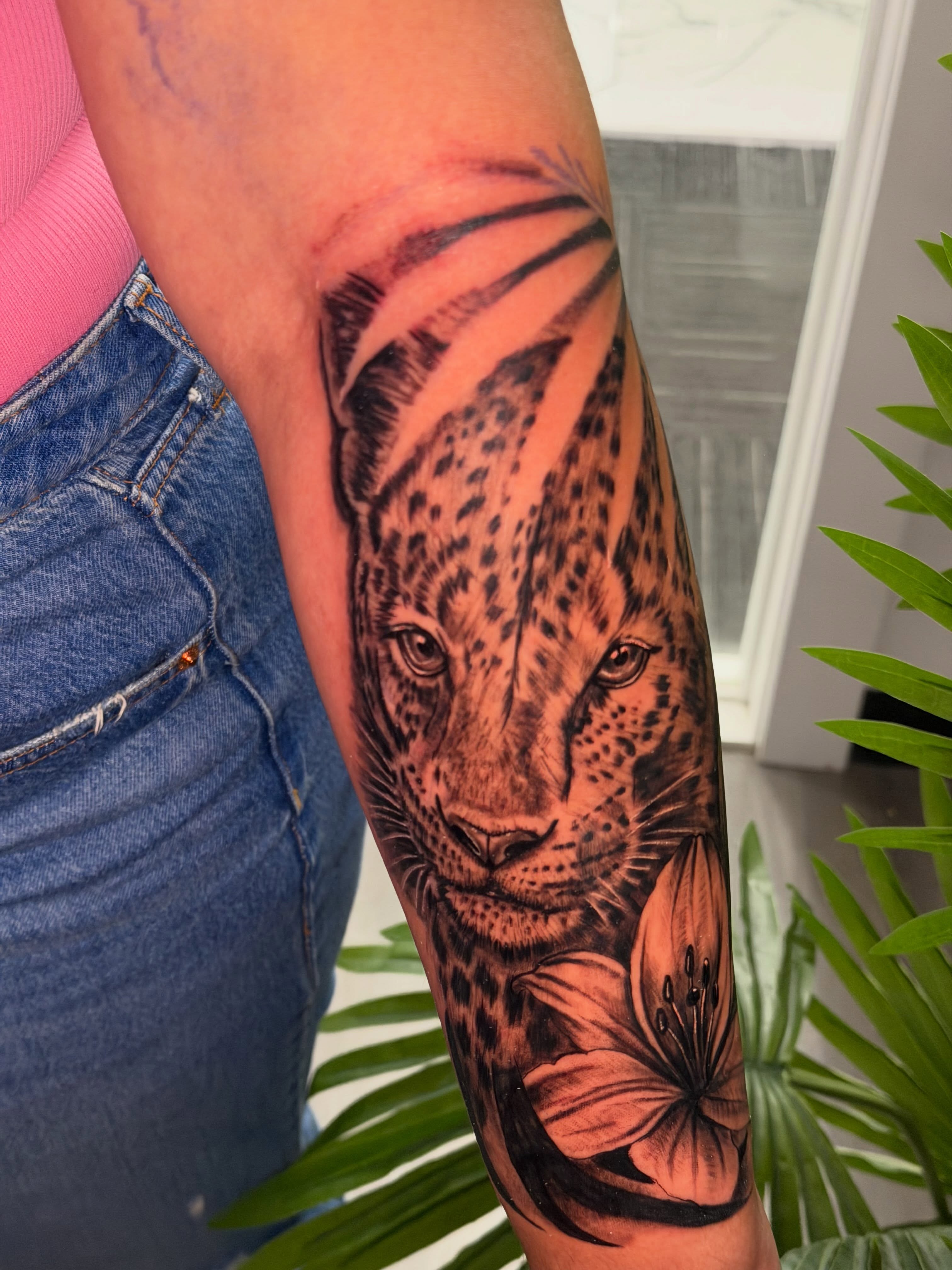Leopard and lily realism tattoo on the forearm by ᴡᴏʀᴍ