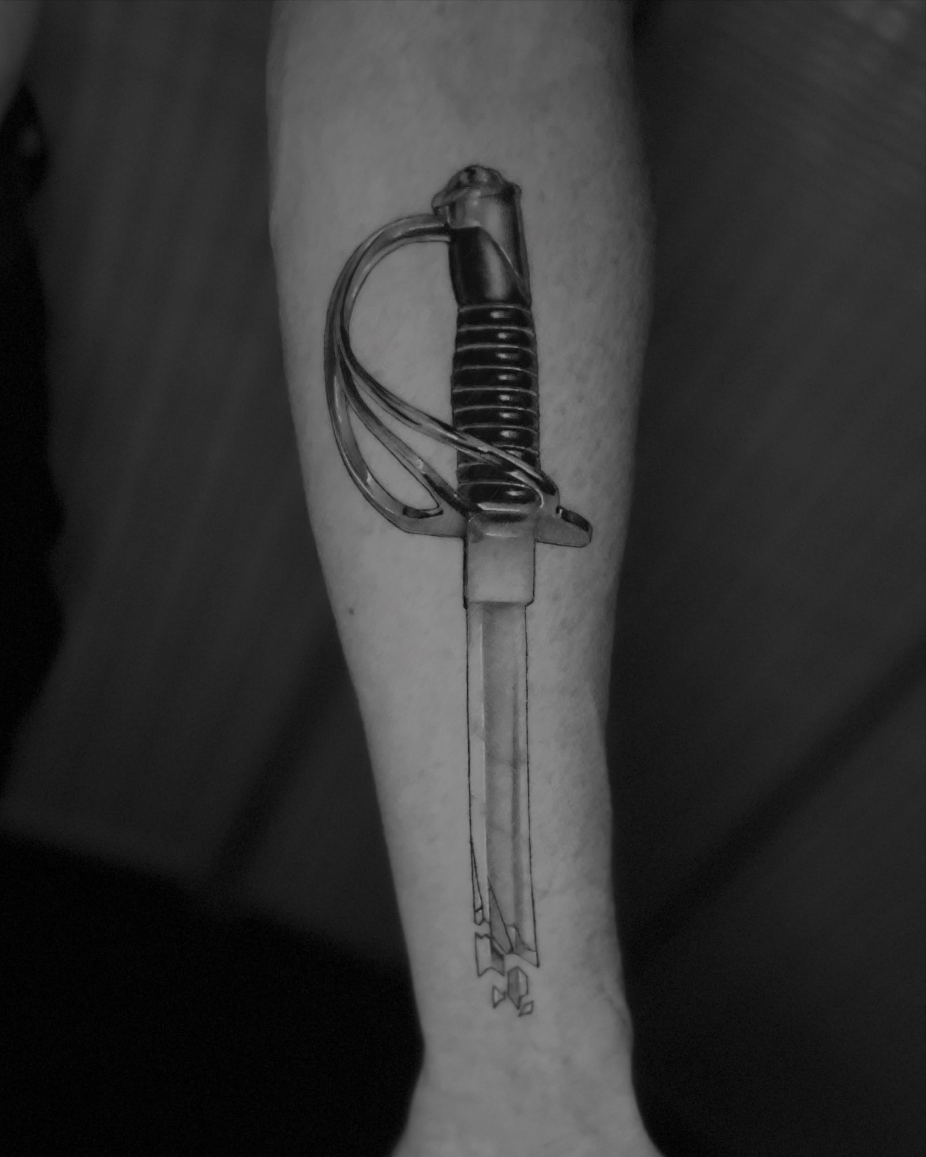 Sword black and grey tattoo on the forearm by Mant