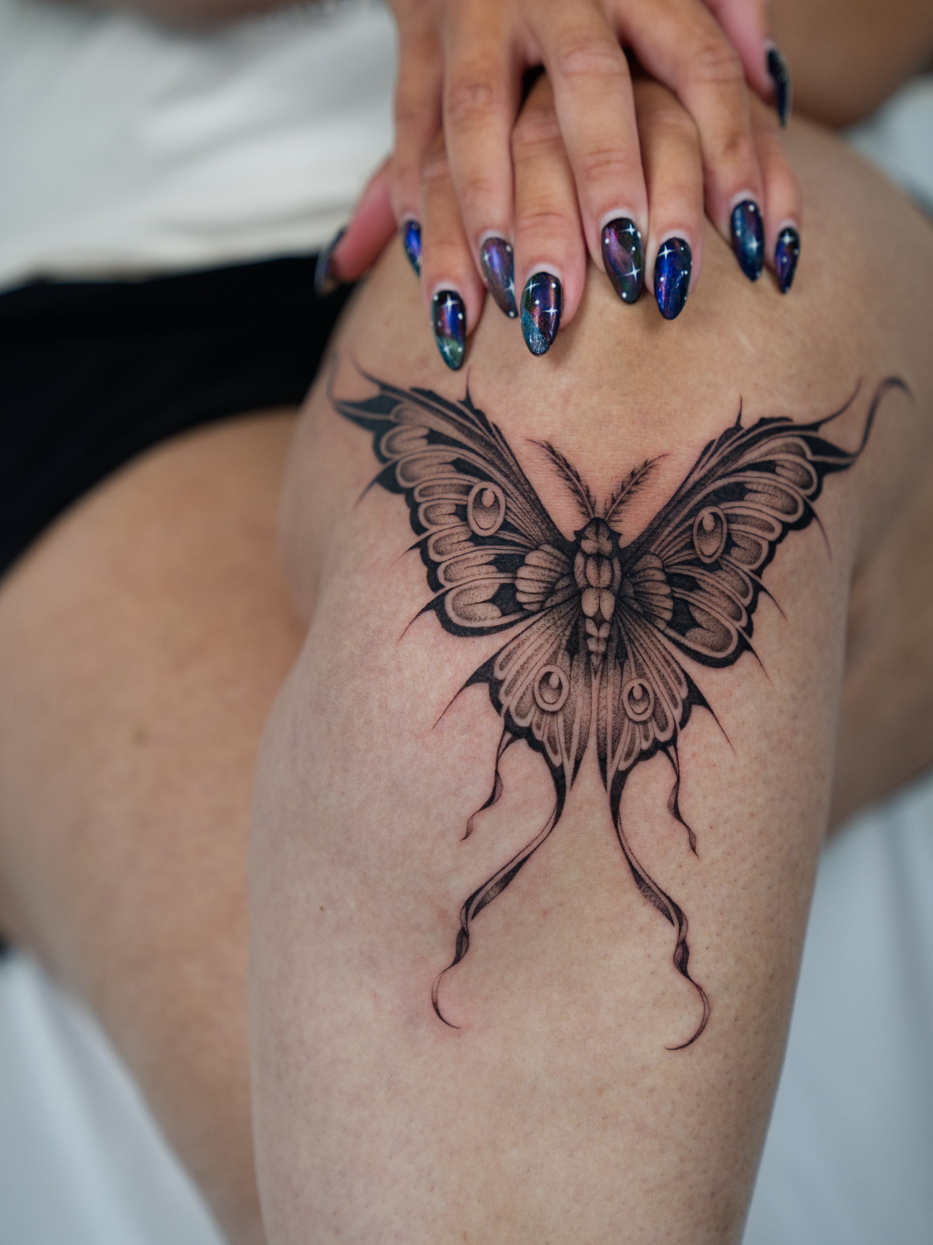 Butterfly black and grey tattoo on the thigh by Gabbie
