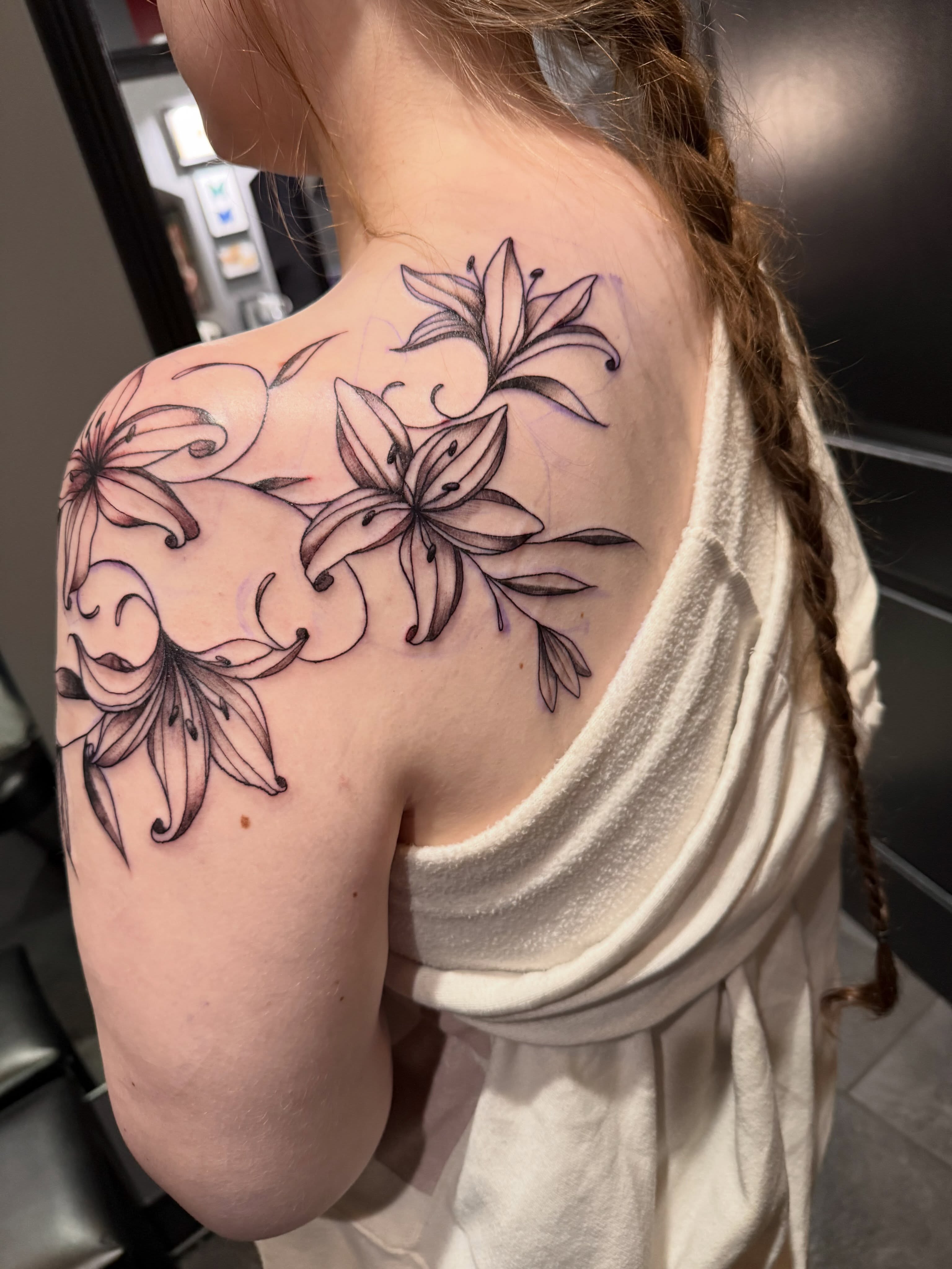 Lilies black and grey tattoo on the shoulder by Courtney