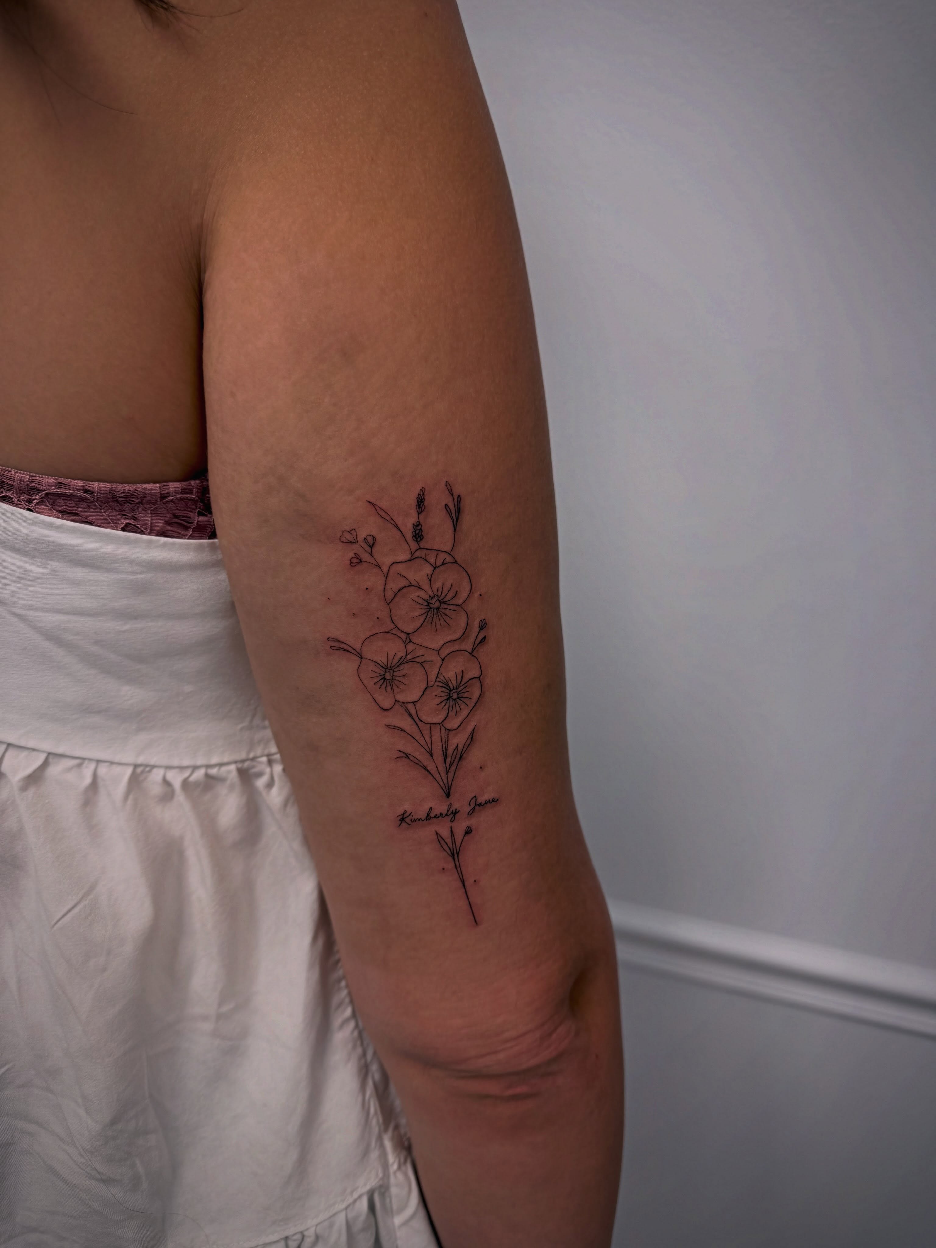 Flowers fine line tattoo on the forearm by Taylor Johnson