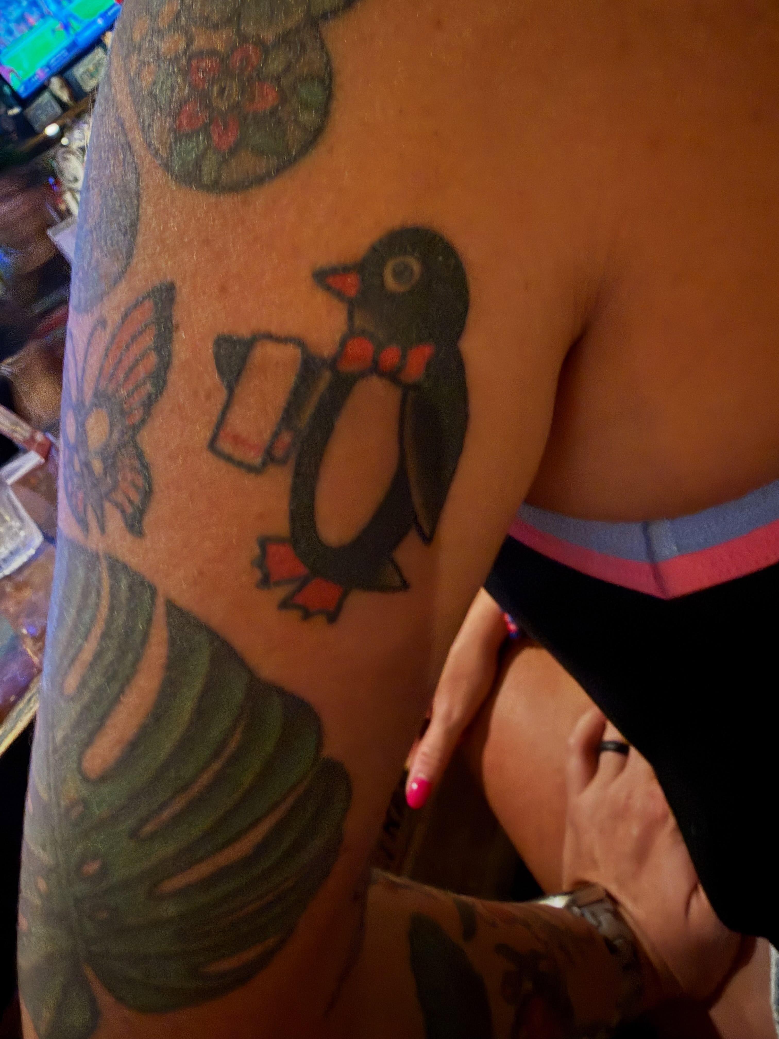 Penguin American traditional tattoo on the upper arm by Cody Dalton
