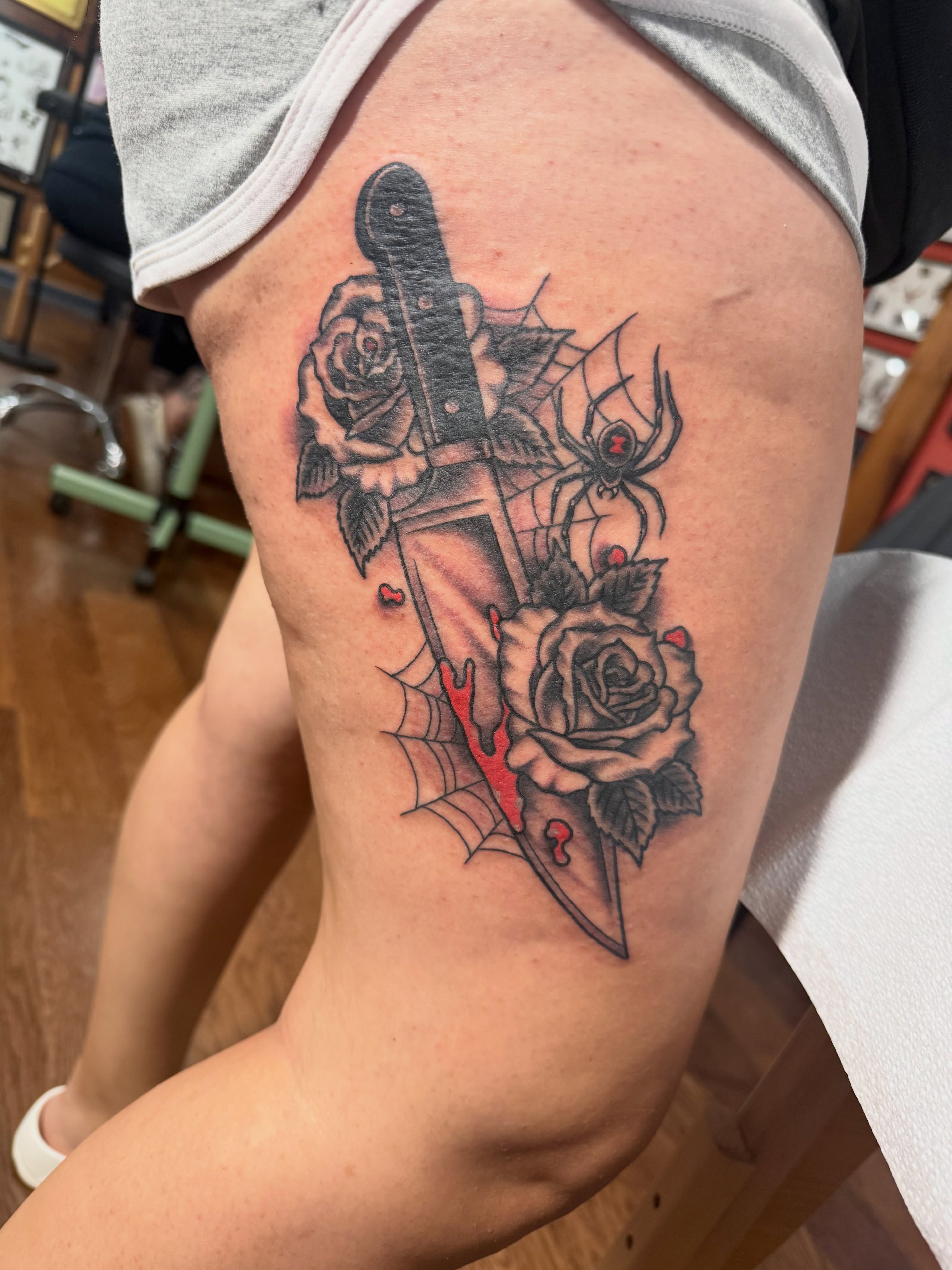 Knife and roses realism tattoo on the thigh by Cody Dalton