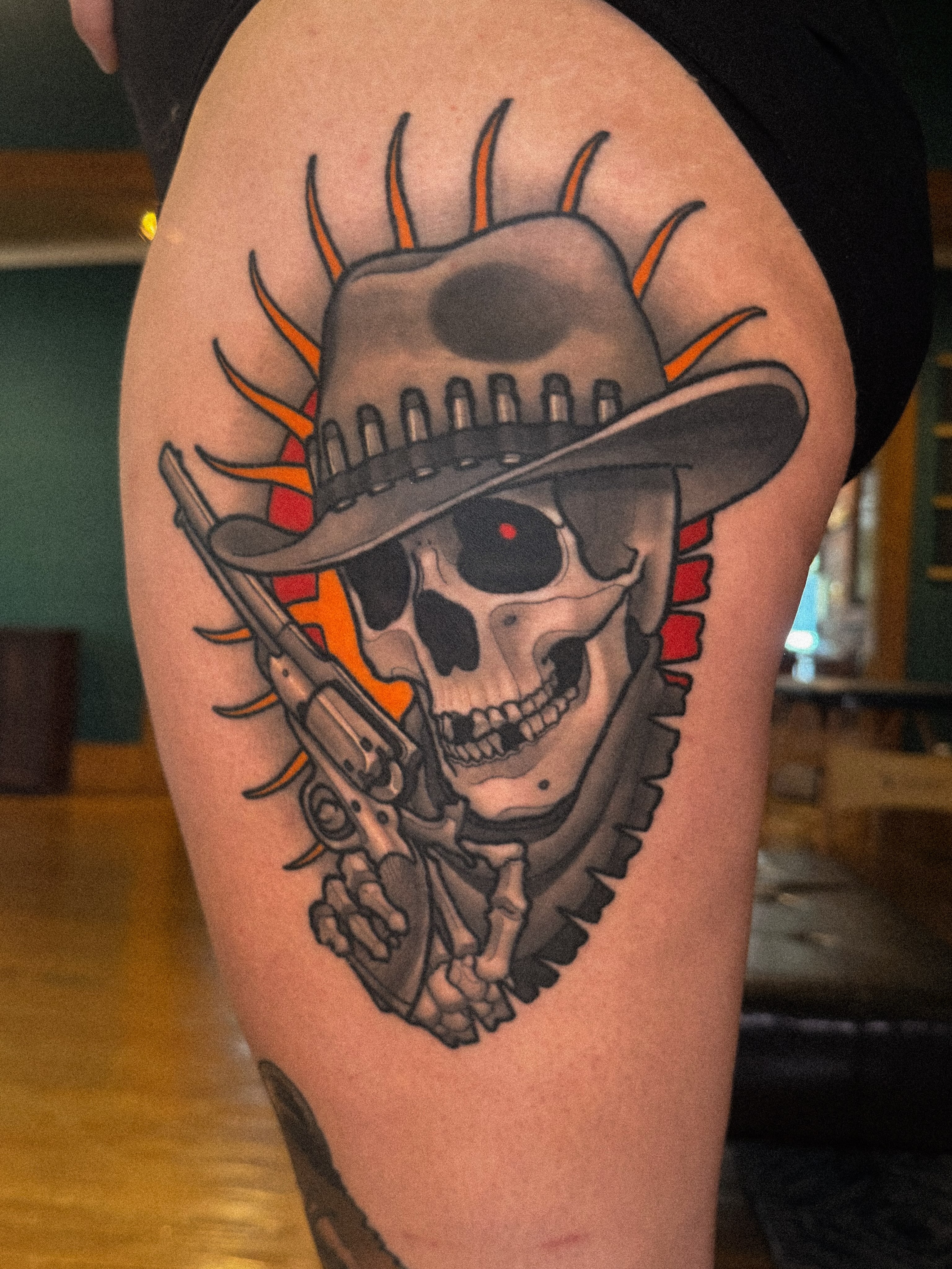 Cowboy skull with revolver American traditional tattoo on the thigh by Nathan Thomas